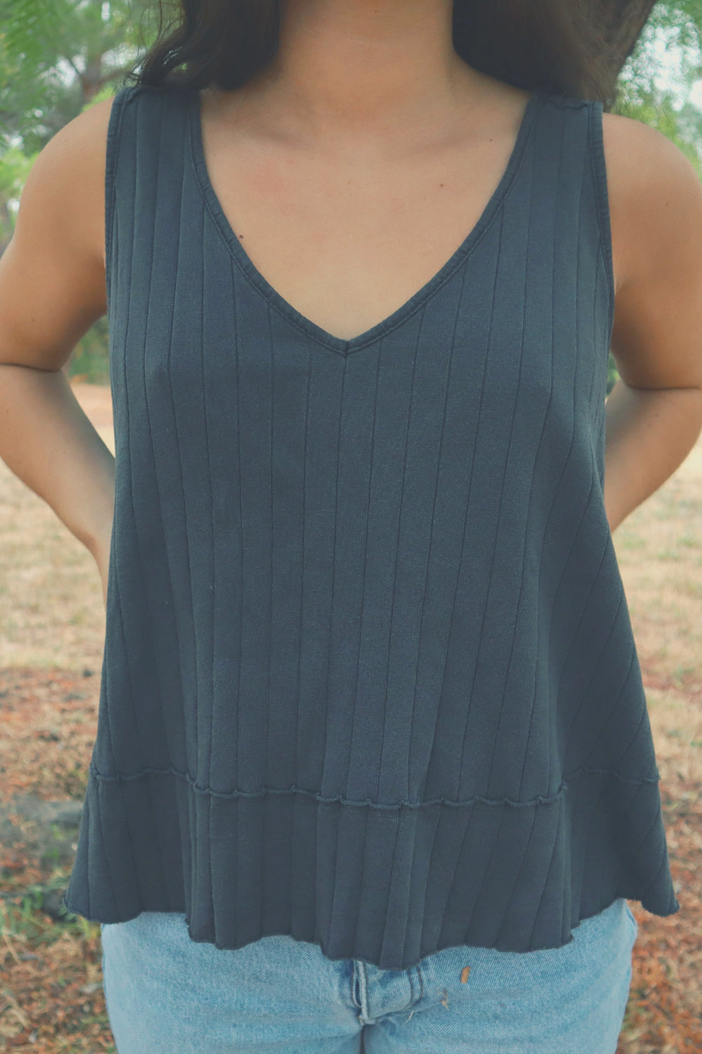 The Swing Tank in washed black, showcasing its ribbed texture and soft cotton fabric, perfect for casual wear or layering.