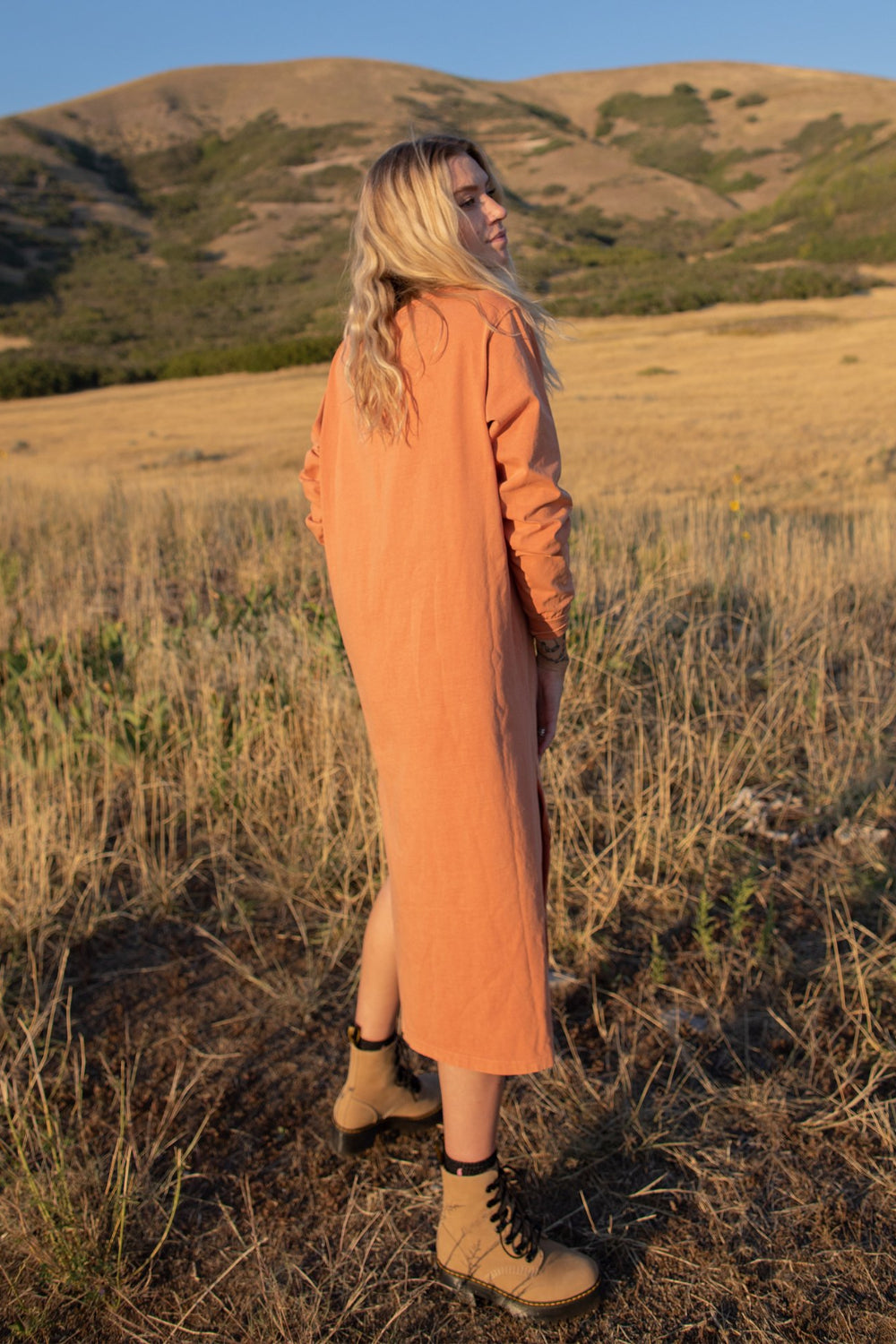 The Taylor Dress in four colors: Brown, Denim, Washed Black, and Peach, featuring long sleeves, a crew neck, and a slight hem slit.