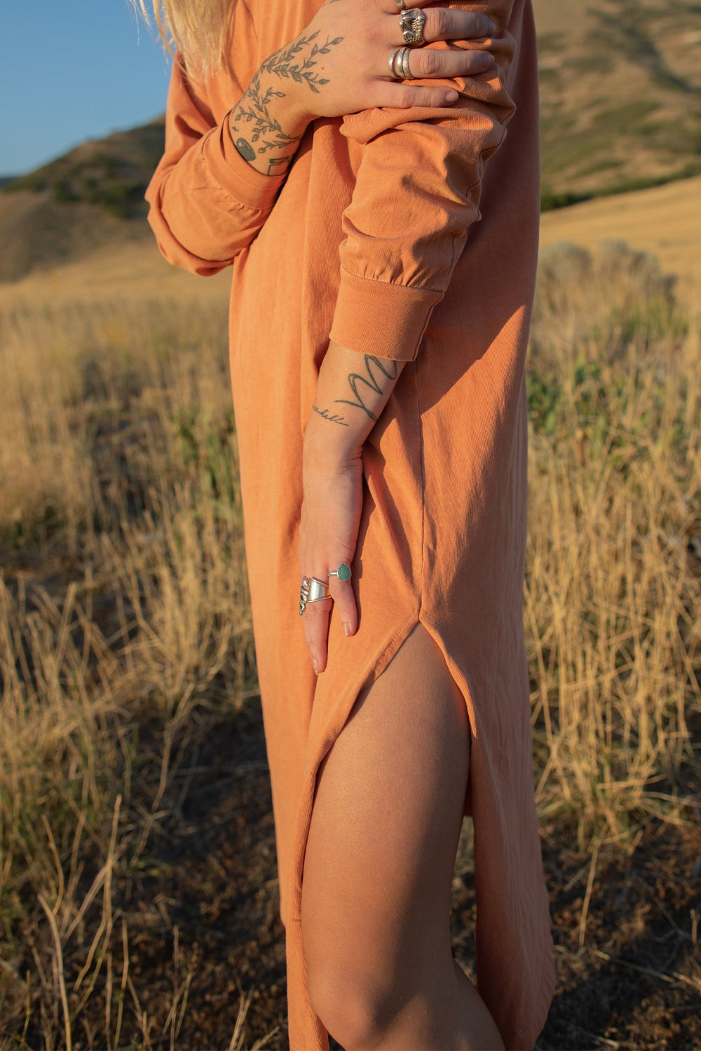 The Taylor Dress in four colors: Brown, Denim, Washed Black, and Peach, featuring long sleeves, a crew neck, and a slight hem slit.