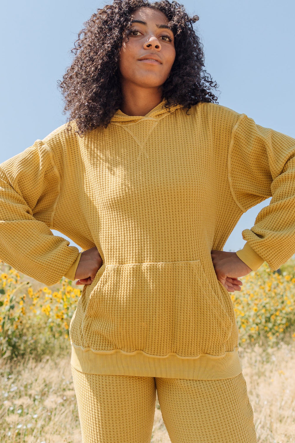 A cozy waffle knit hoodie in a relaxed fit, featuring a drawstring hood, made from 100% organic cotton.