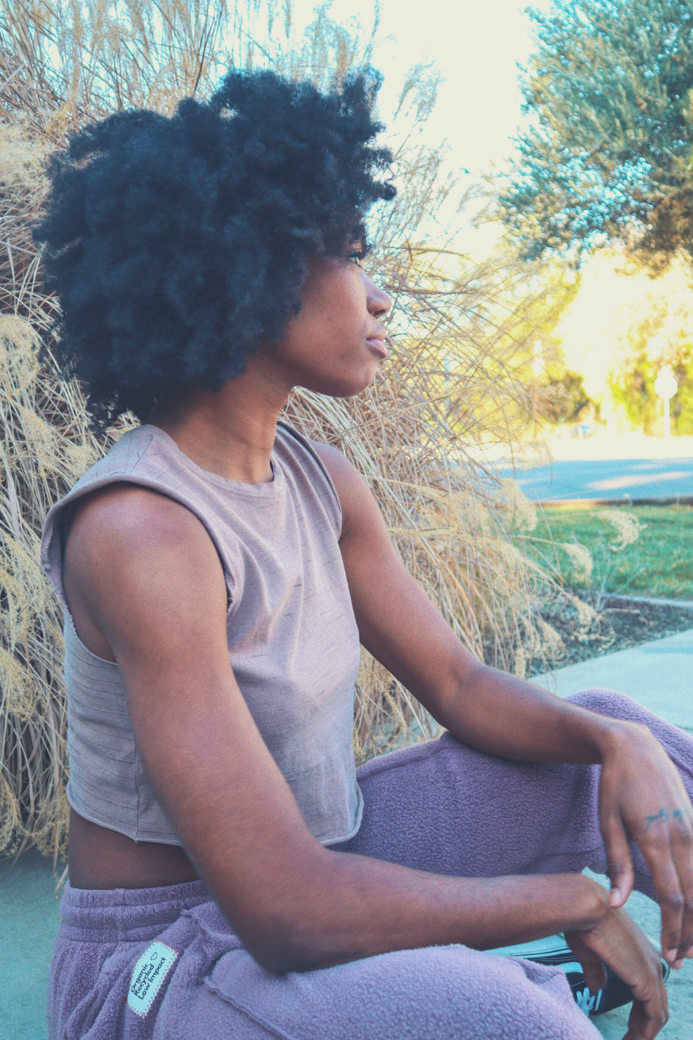 Person sitting outdoors in sunlight.