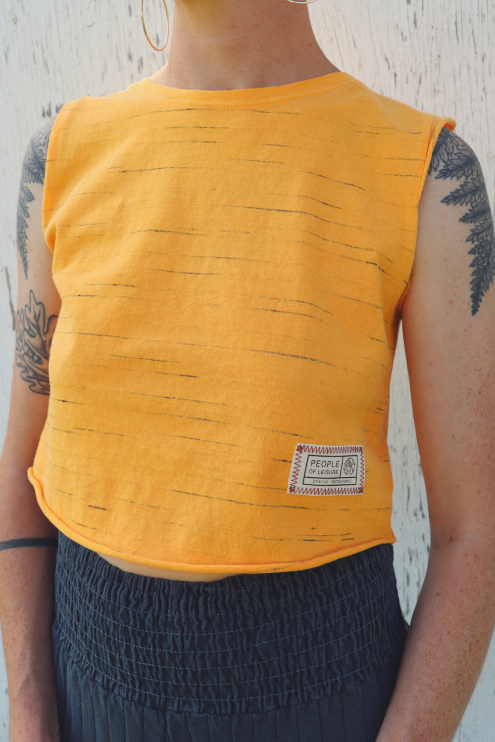 Person wearing yellow sleeveless top.