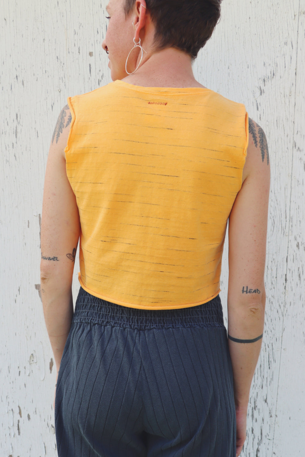 Person wearing yellow sleeveless top.