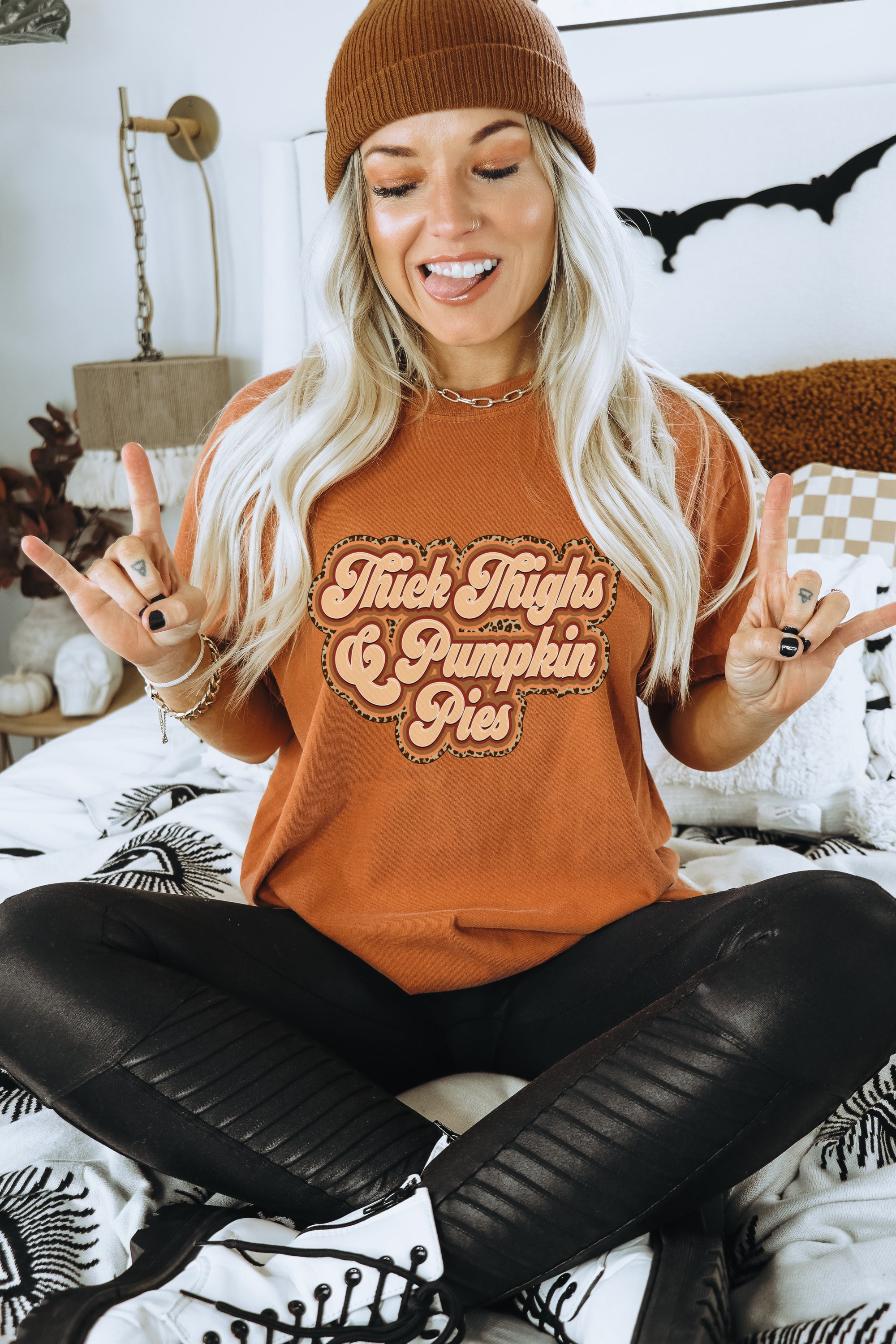 A stylish women's fitted tee featuring the graphic 'Thick Thighs & Pumpkin Pies' in a vibrant color, showcasing its soft fabric and modern design.