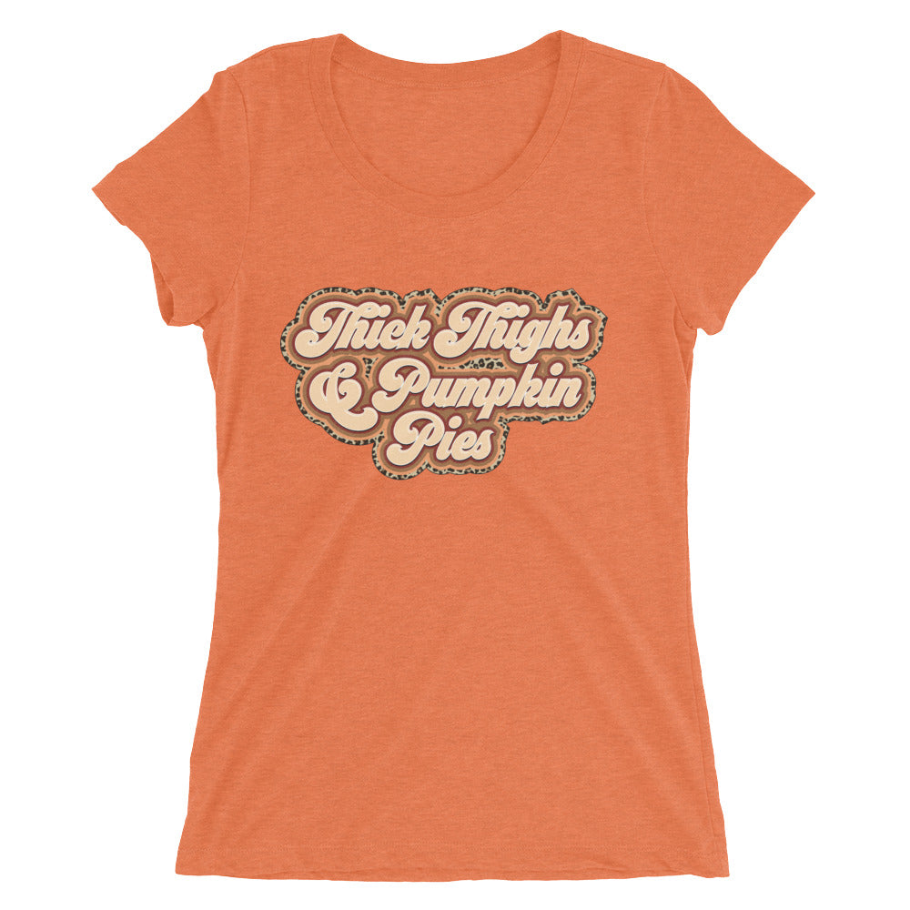 A stylish women's fitted tee featuring the graphic 'Thick Thighs & Pumpkin Pies' in a vibrant color, showcasing its soft fabric and modern design.