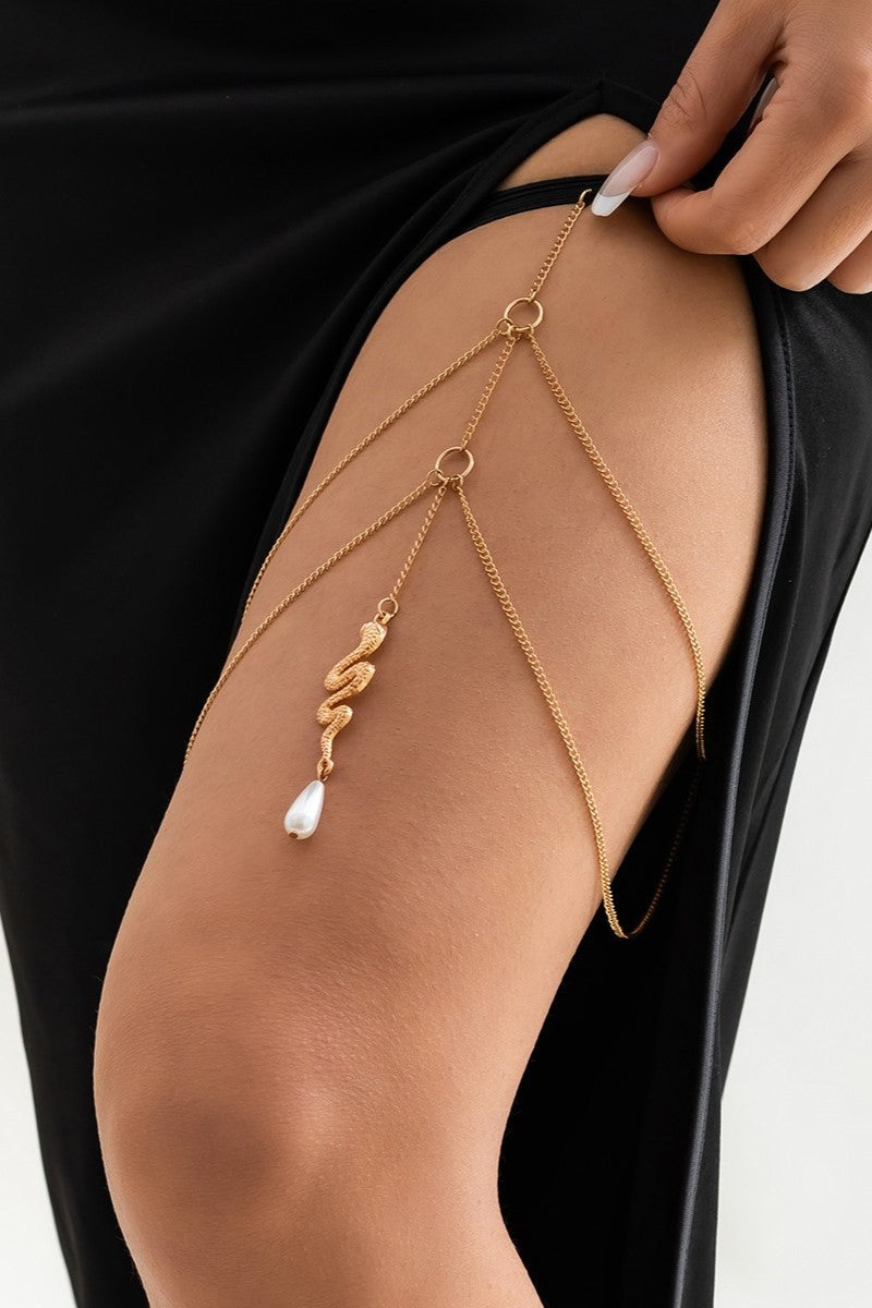 Gold thigh chain featuring a snake-shaped pendant, elegantly designed with fine chains and an elastic band for comfort.