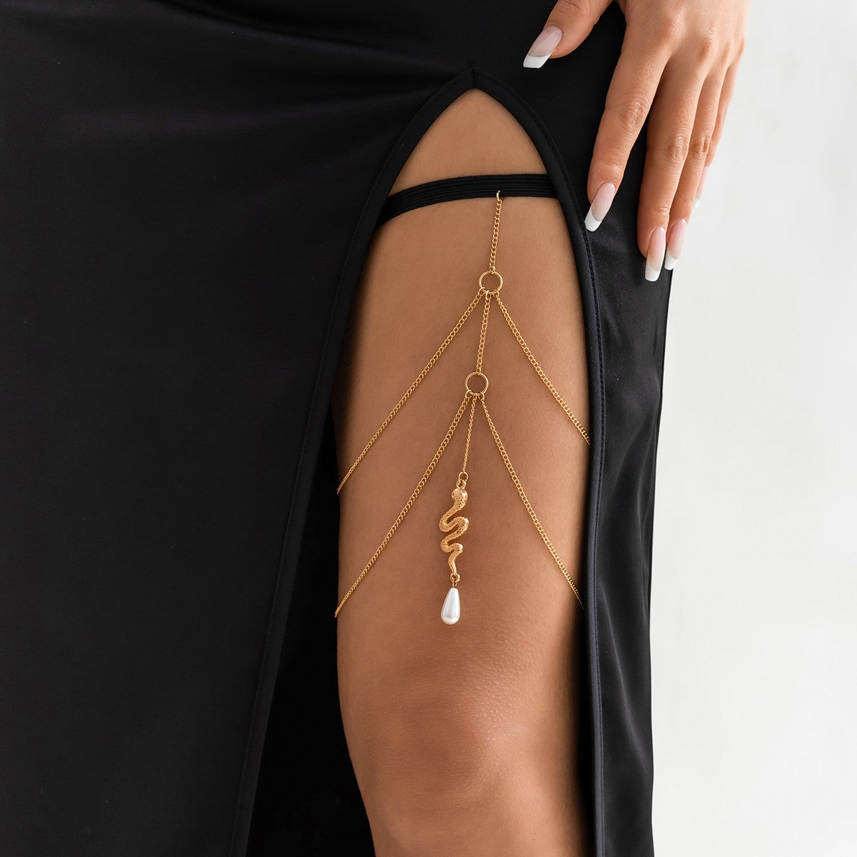 Gold thigh chain featuring a snake-shaped pendant, elegantly designed with fine chains and an elastic band for comfort.