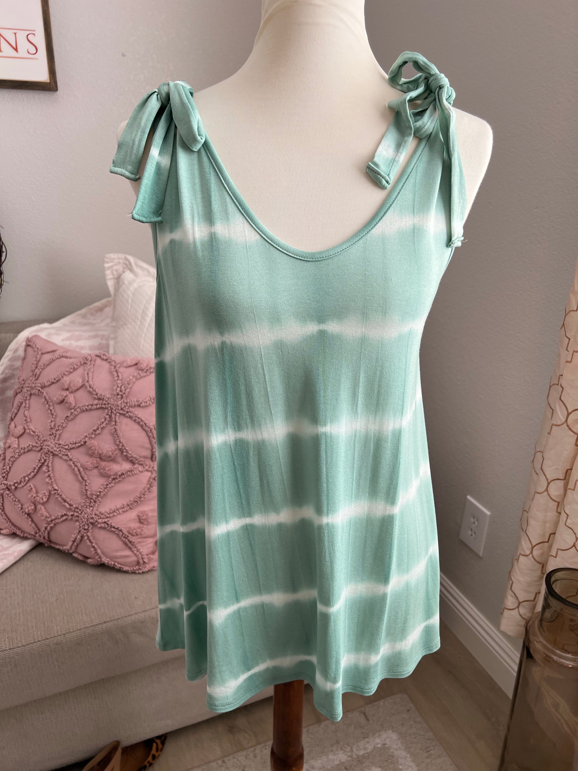 A vibrant tie dye top featuring faux shoulder ties, designed for a trendy and comfortable fit in size small.