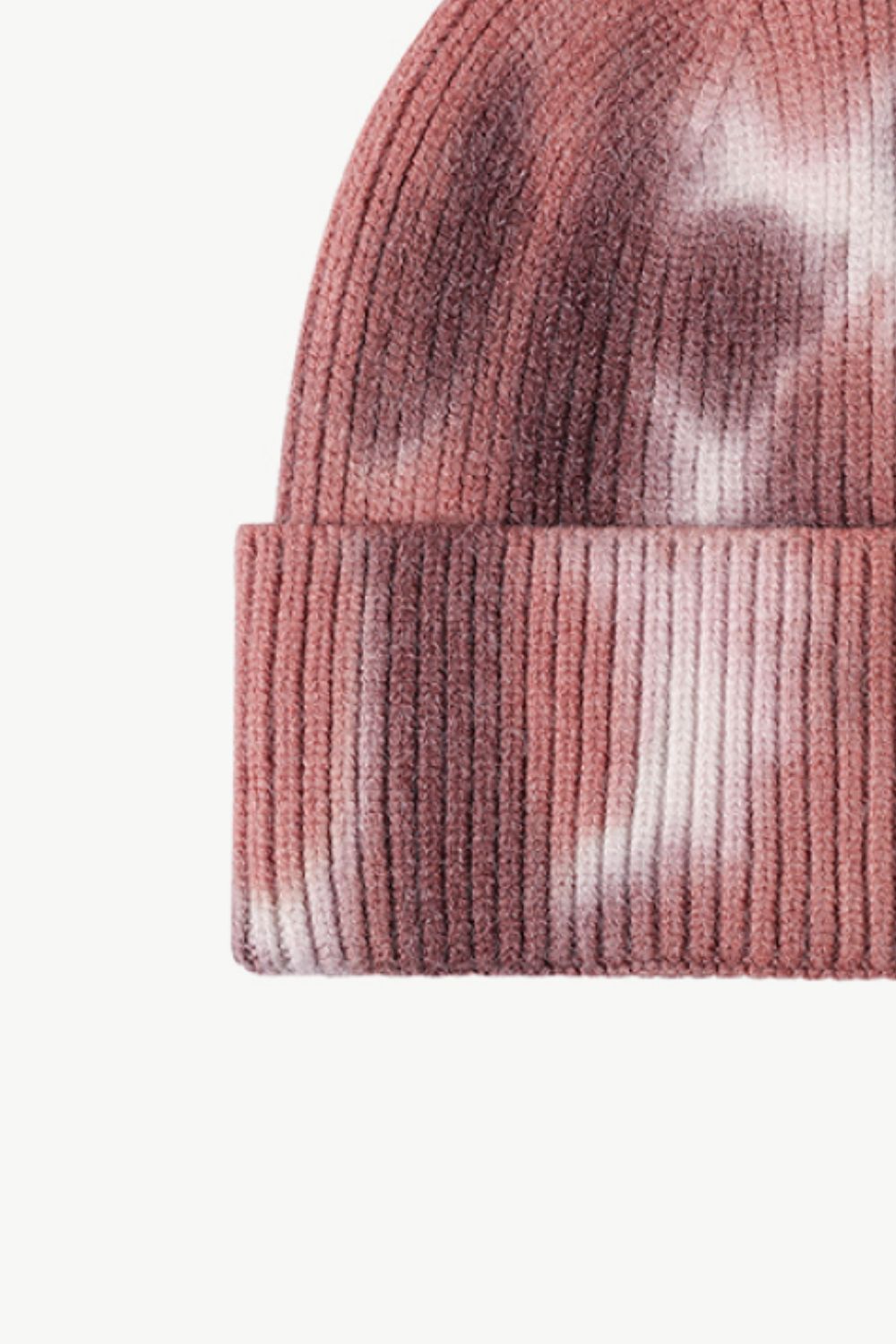 A colorful tie-dye cuffed knit beanie displayed in a flat lay style, showcasing its vibrant patterns and soft texture.