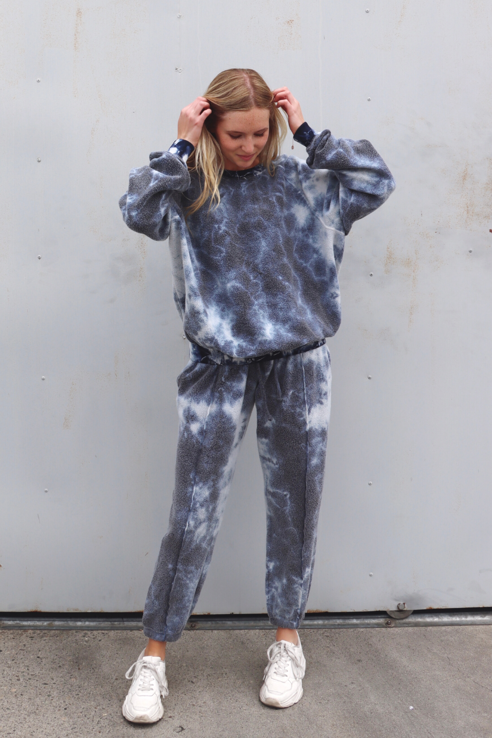 A pair of stylish tie-dye sweatpants featuring a unique blend of blue, pink, and black colors, designed for comfort and leisure.