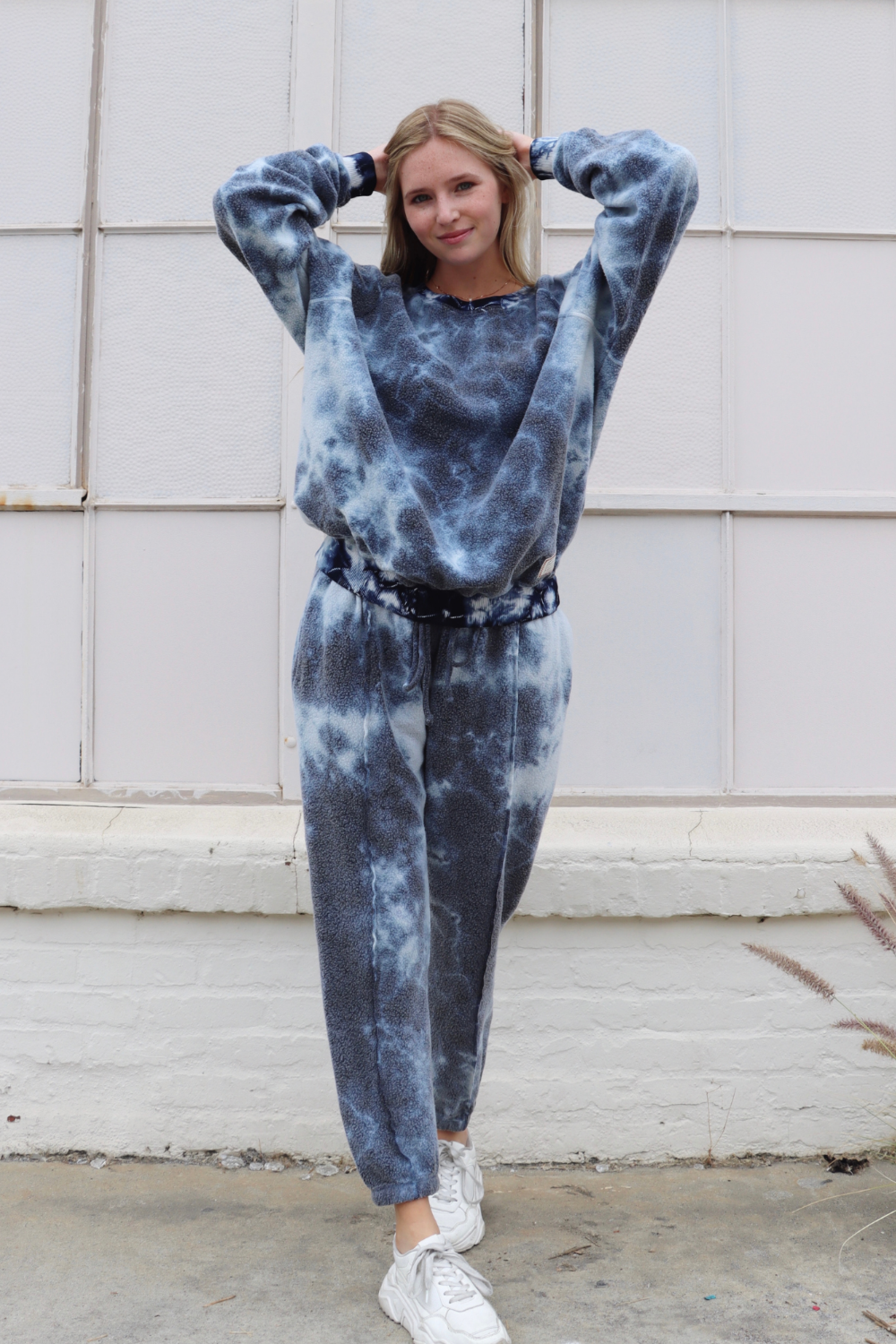 A pair of stylish tie-dye sweatpants featuring a unique blend of blue, pink, and black colors, designed for comfort and leisure.