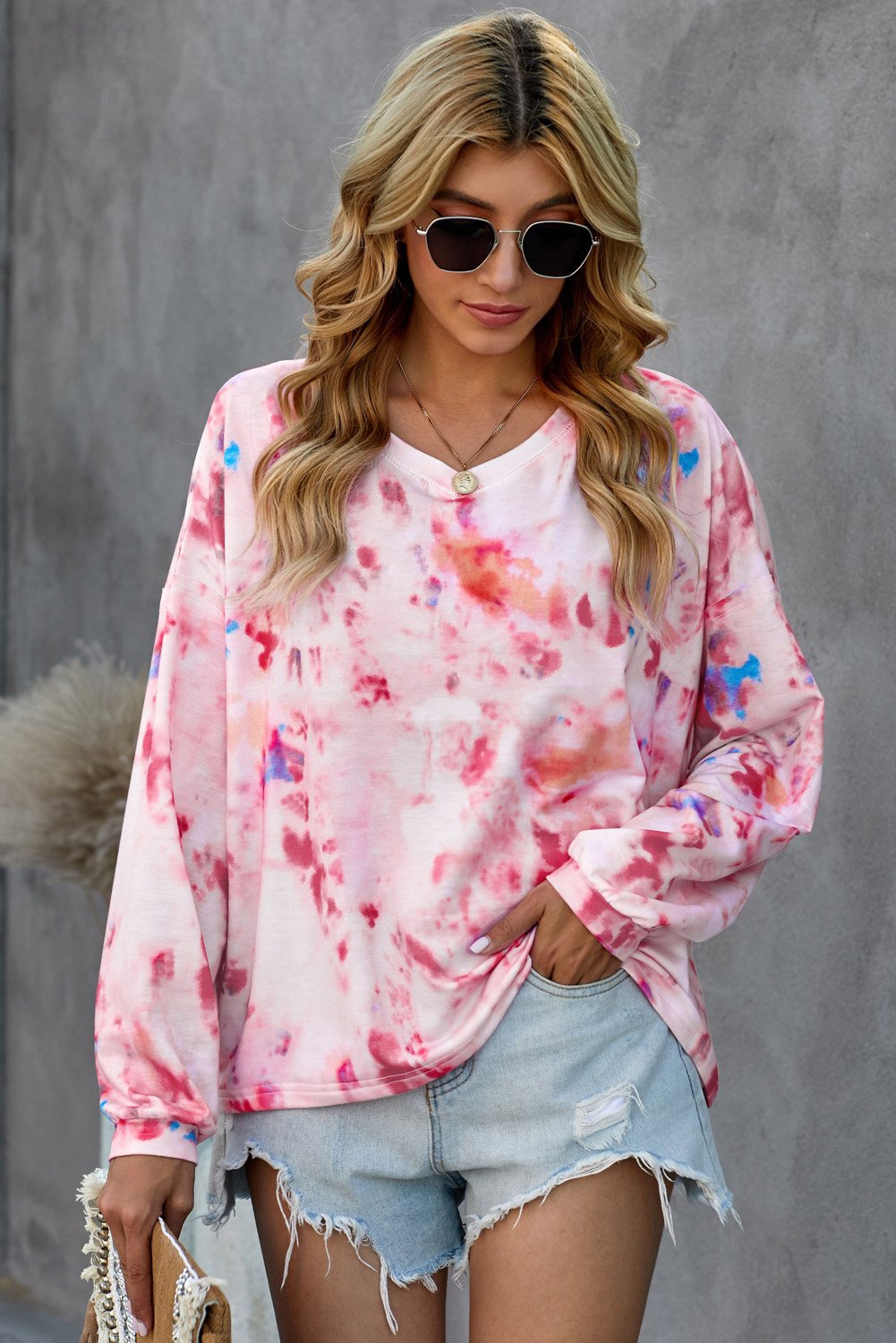 A vibrant pink tie-dye V neck long sleeve top with bubble sleeves and an irregular hemline, perfect for autumn fashion.