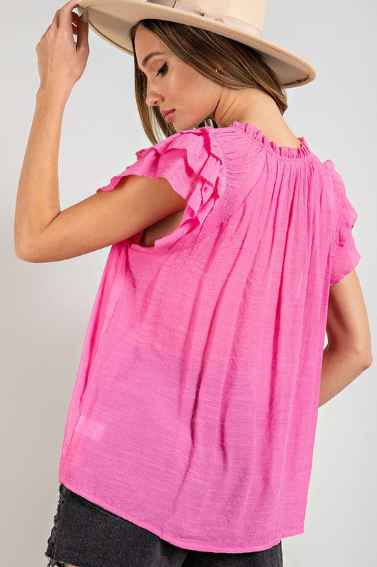 A stylish tiered ruffle sleeve short sleeve blouse with a neck tie, showcasing elegant ruffle details and a soft fabric blend.