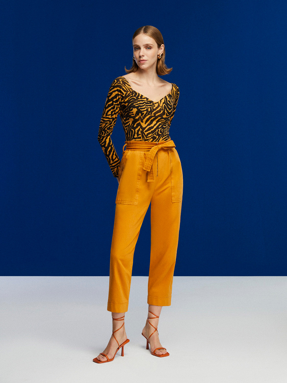 Tiger Print Bodysuit featuring a wide neck, open back, and long sleeves in a warm brown color.