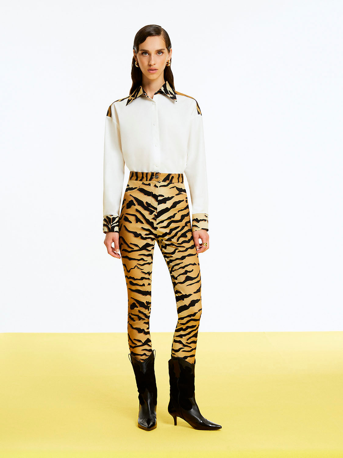 A pair of stylish tiger print high-waisted pants featuring a fitted ankle-length design with hidden zipper detail at the hem.