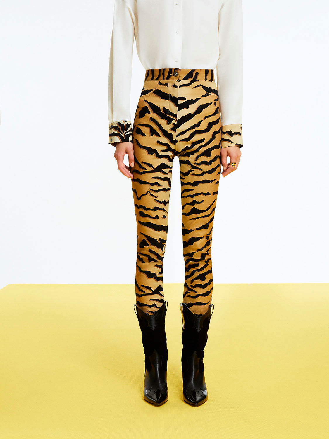 A pair of stylish tiger print high-waisted pants featuring a fitted ankle-length design with hidden zipper detail at the hem.