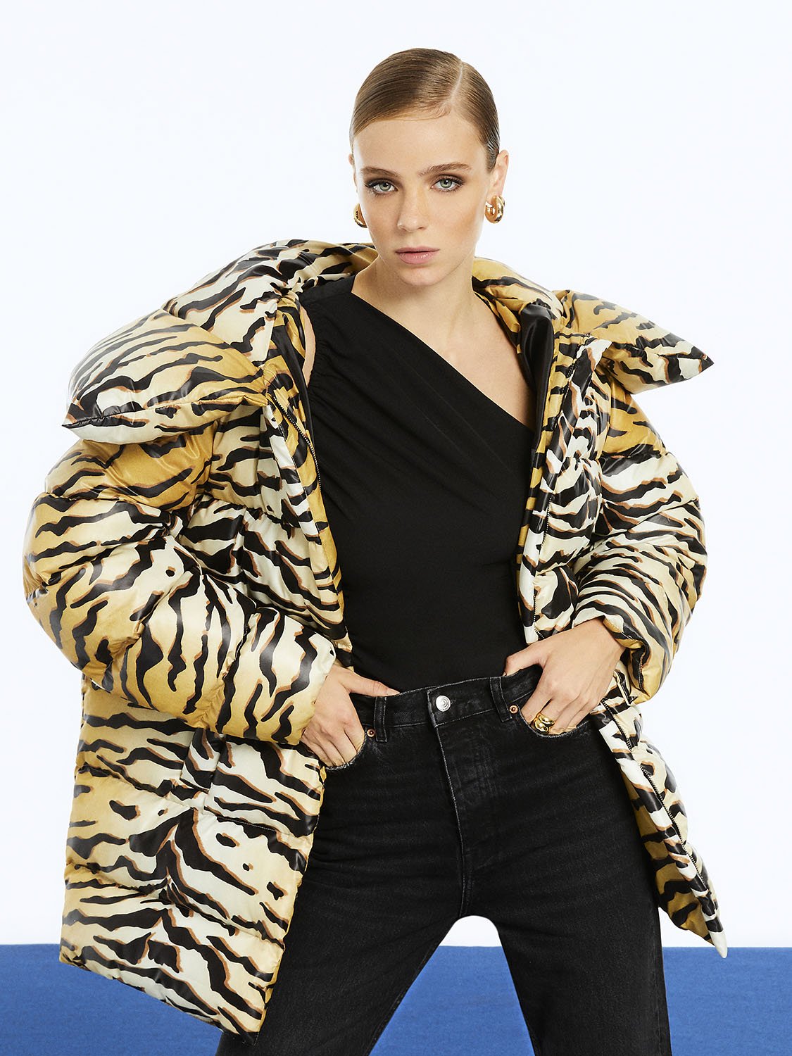 Oversized tiger print puffer jacket with hood and front zipper closure, showcasing stylish side pockets.