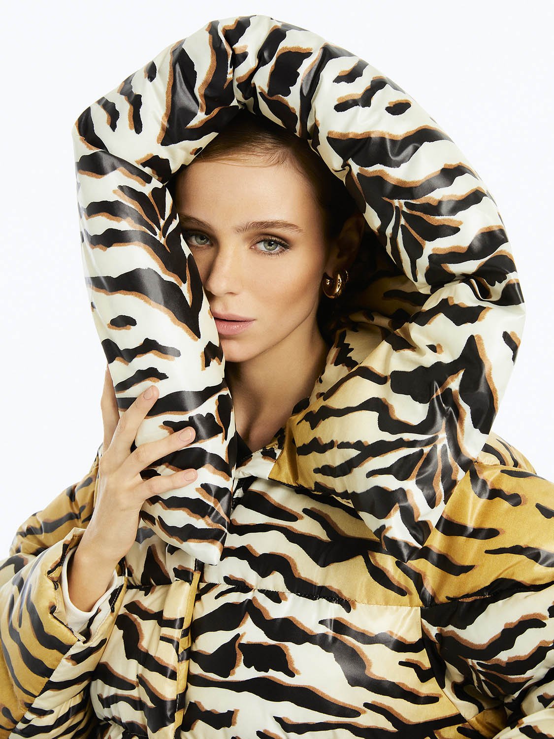 Oversized tiger print puffer jacket with hood and front zipper closure, showcasing stylish side pockets.