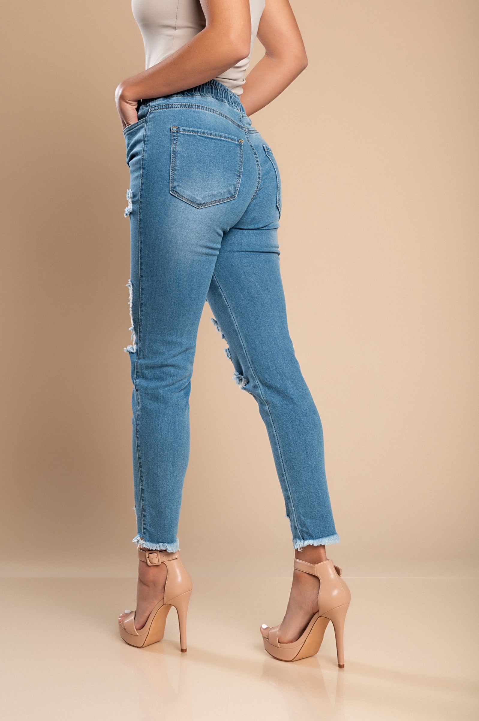 Sky blue tight jeans with high waist and fashionable slits, featuring ripped edges and pockets.