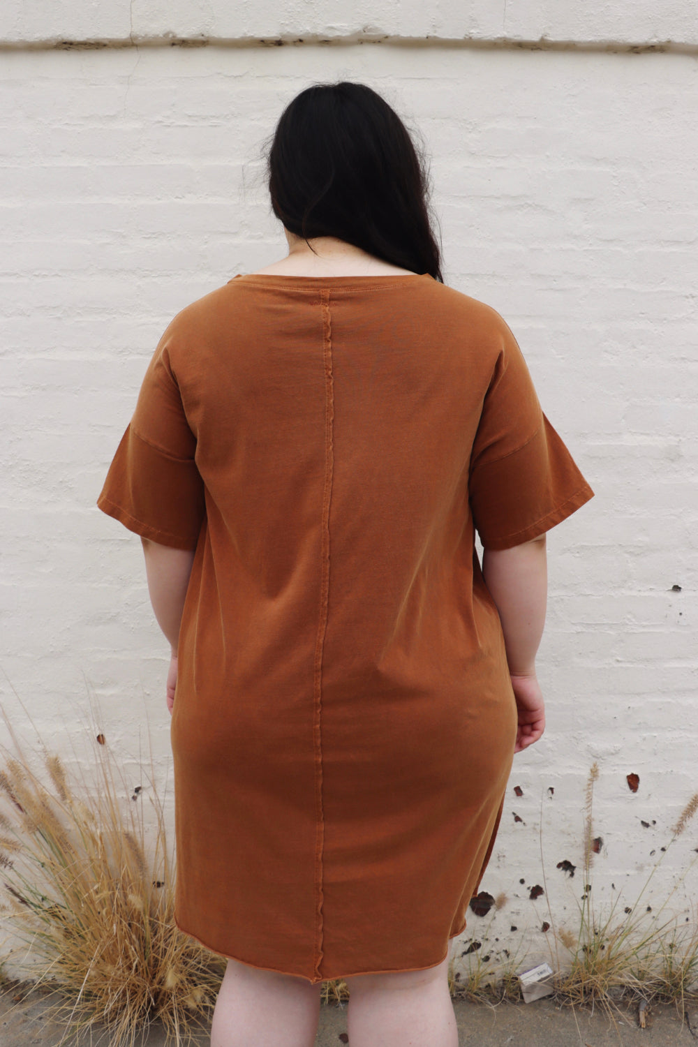 A relaxed fit Topanga Dress in saddle color, made from 100% organic cotton, displayed on a mannequin with sandals and a tote.