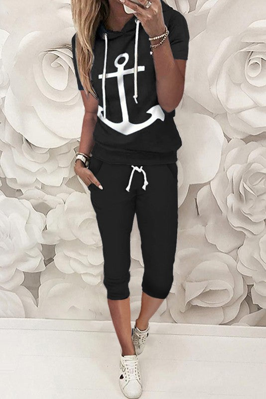 Aisla tracksuit featuring a stylish anchor print on a black T-shirt and matching 3/4 length pants with front pockets.