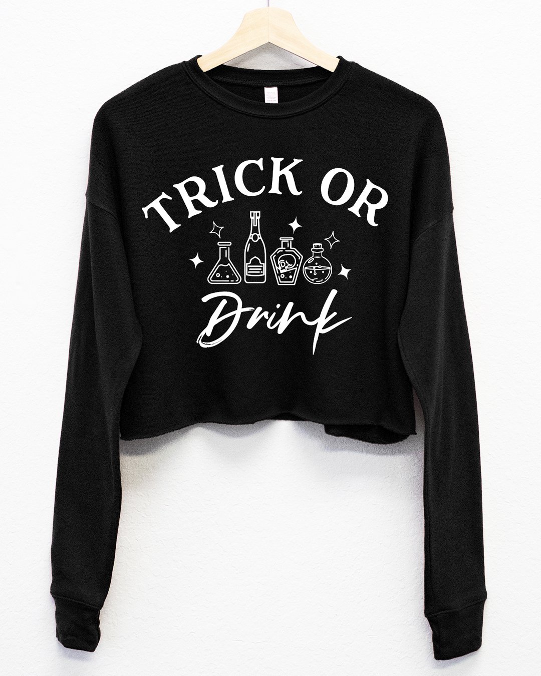 Trick or Drink Fleece Cropped Sweatshirt in black and burnt orange, featuring a playful Halloween design.