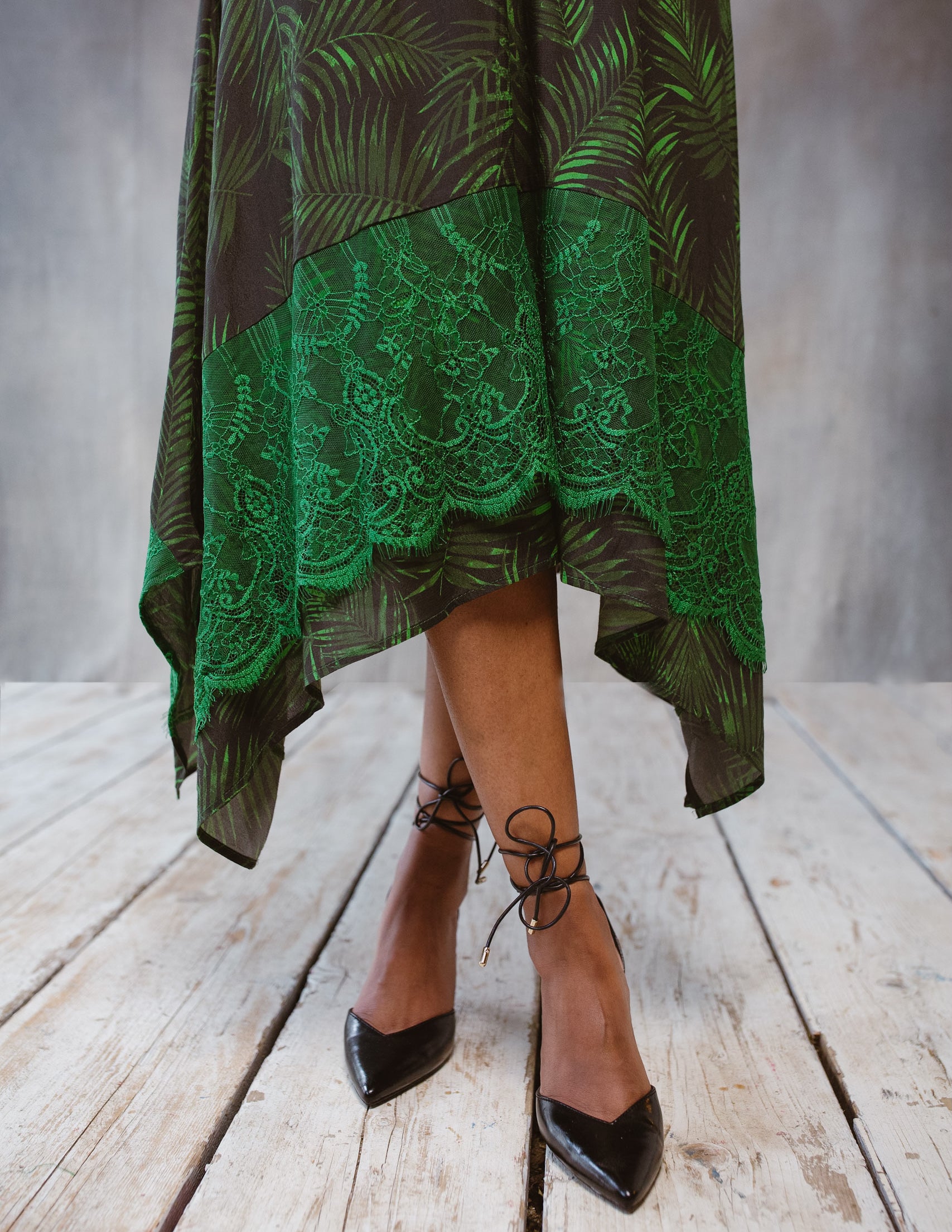 A stylish Tropical Print Dress featuring lace accents, statement sleeves, and an asymmetric hem, perfect for various occasions.