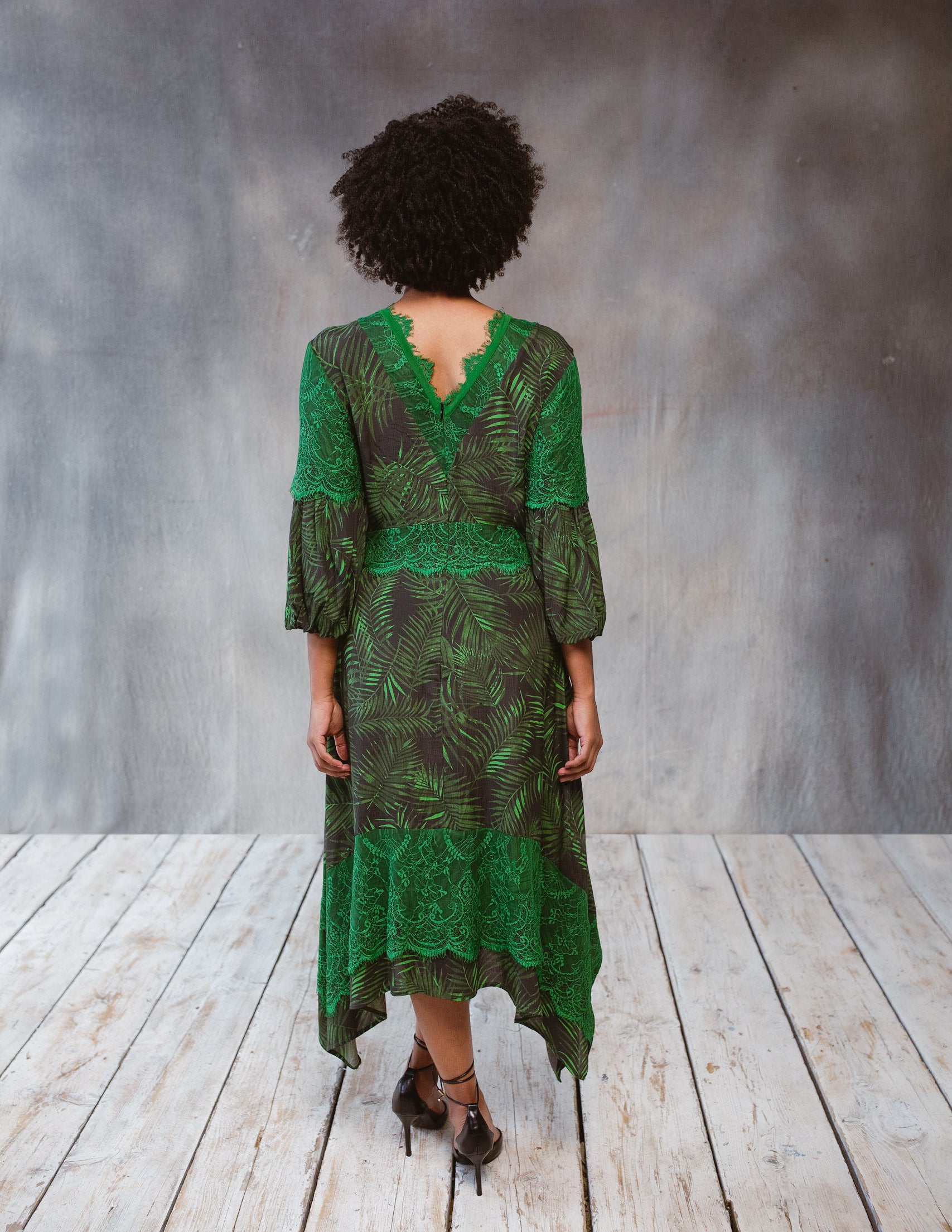 A stylish Tropical Print Dress featuring lace accents, statement sleeves, and an asymmetric hem, perfect for various occasions.