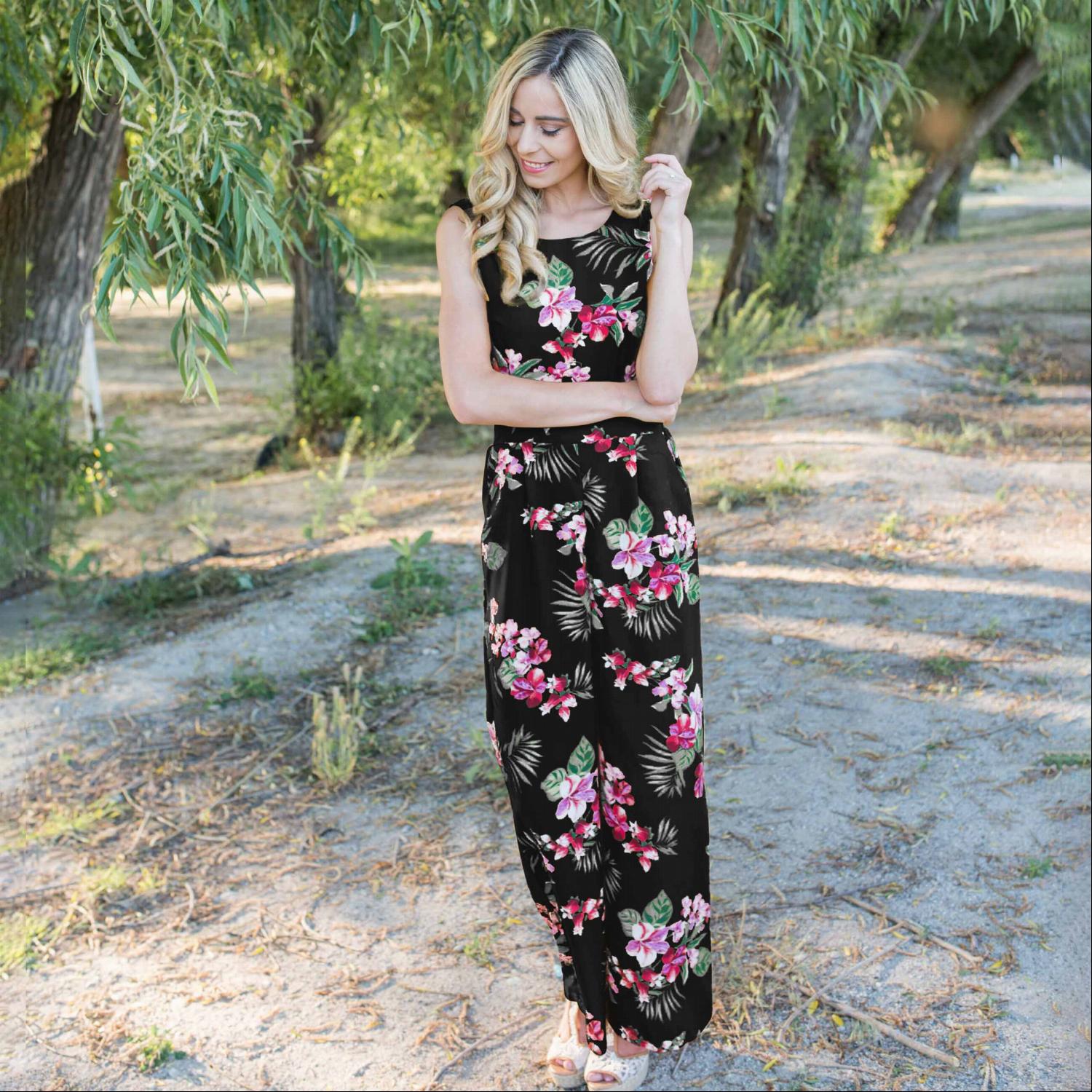 A stylish Tropical Tie Back Jumpsuit featuring a vibrant floral pattern, deep V back, and wide leg design, perfect for summer outings.