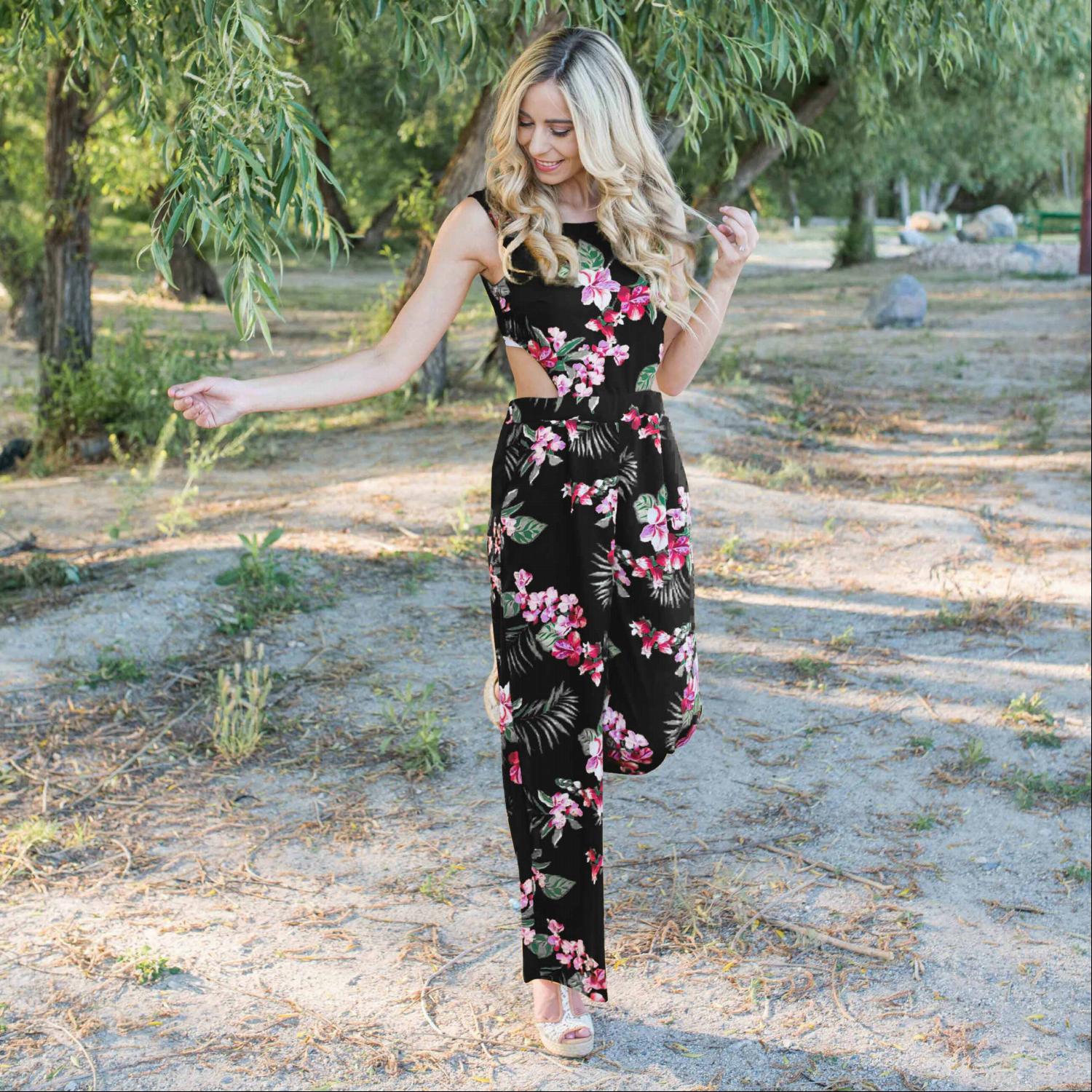 A stylish Tropical Tie Back Jumpsuit featuring a vibrant floral pattern, deep V back, and wide leg design, perfect for summer outings.