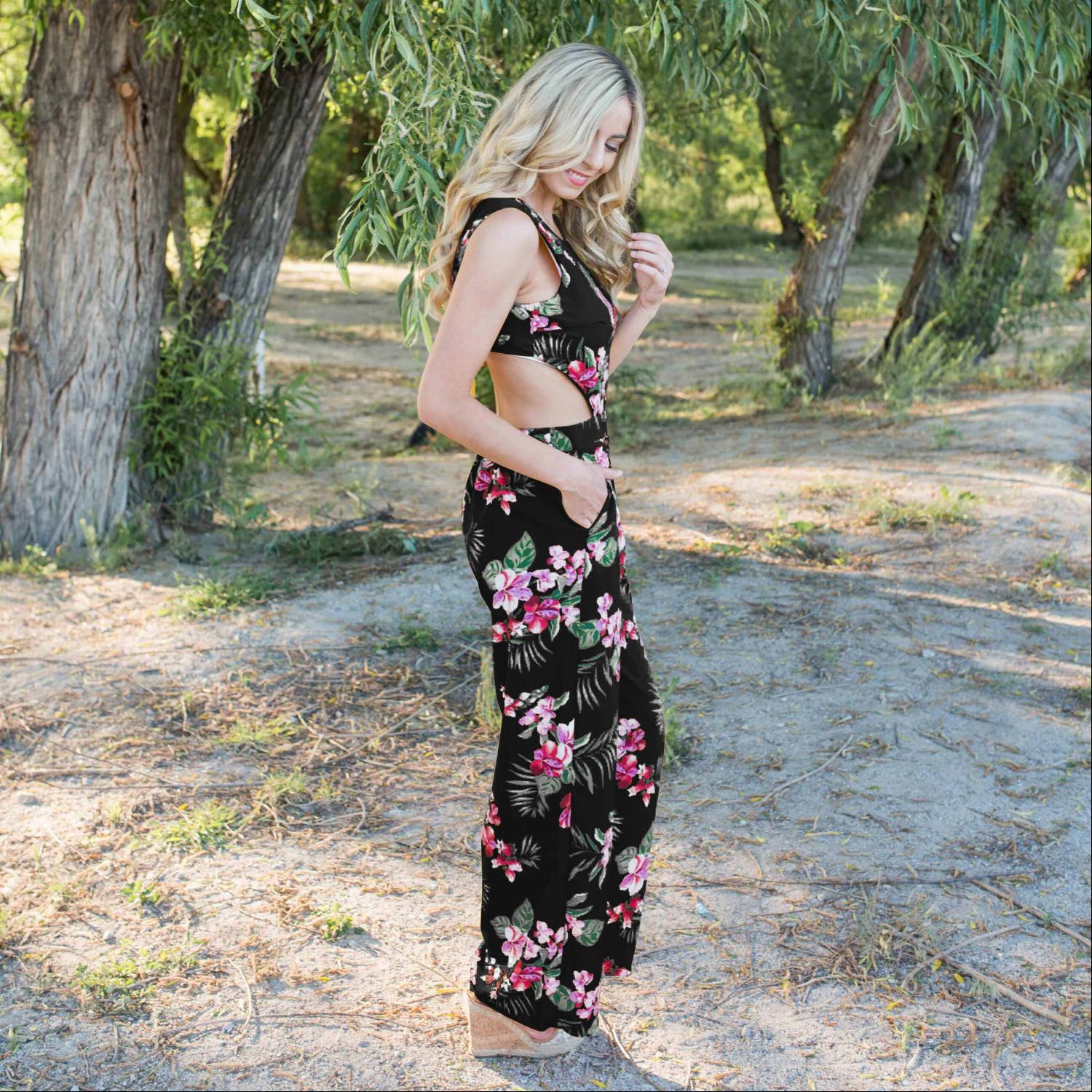 A stylish Tropical Tie Back Jumpsuit featuring a vibrant floral pattern, deep V back, and wide leg design, perfect for summer outings.