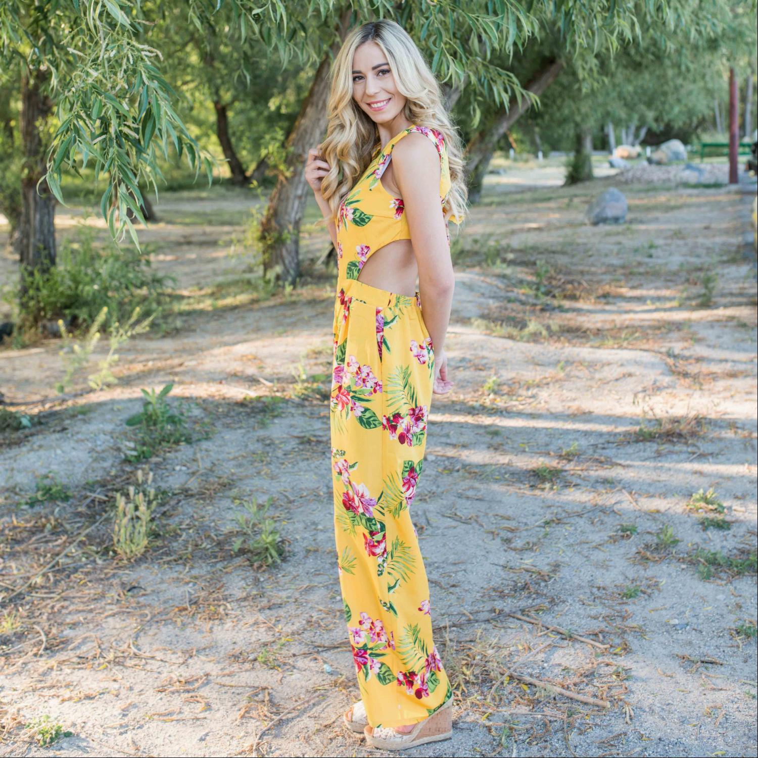 A stylish Tropical Tie Back Jumpsuit featuring a vibrant floral pattern, deep V back, and wide leg design, perfect for summer outings.