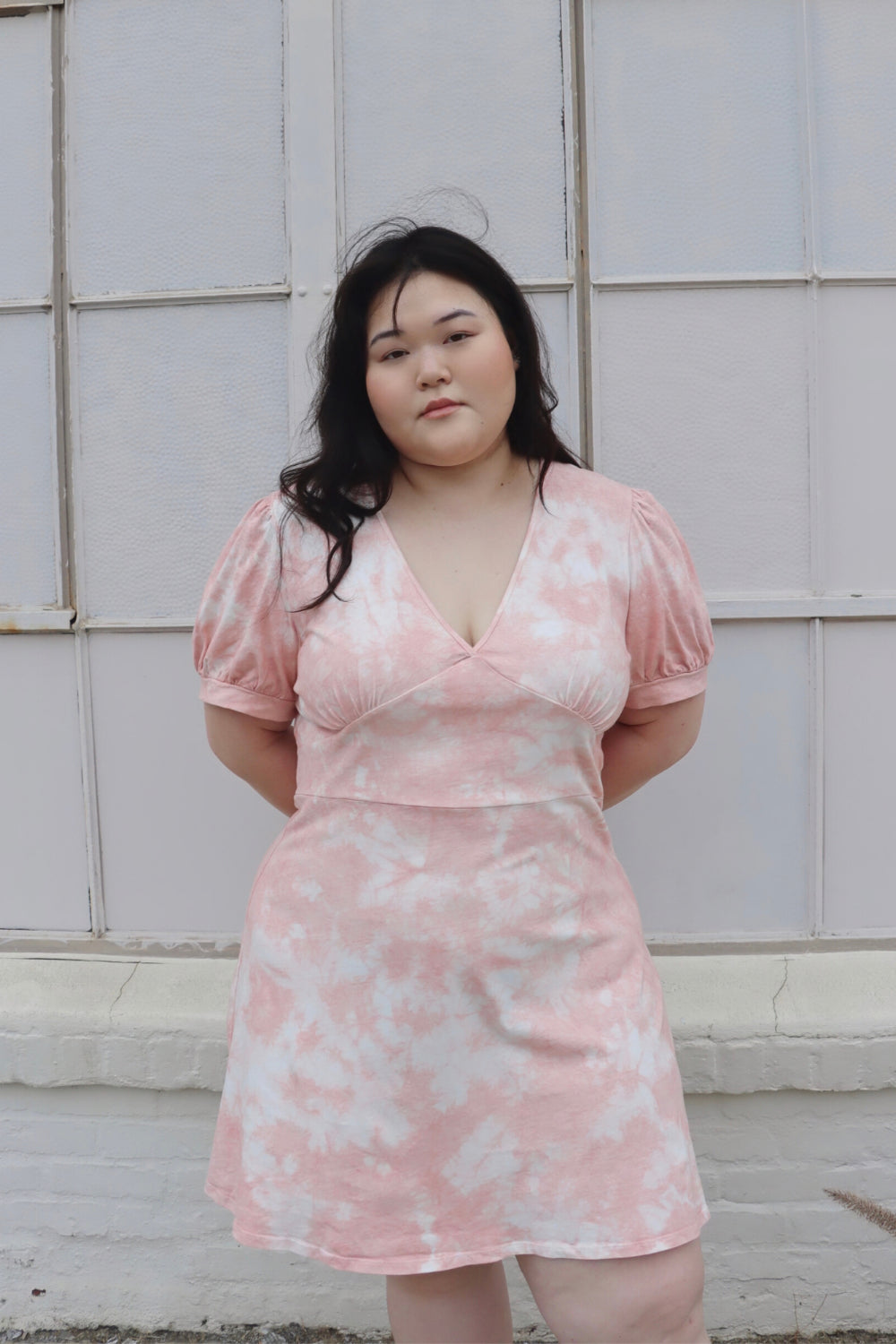 True Romance Dress featuring short puff sleeves and a fitted waist, hand dyed in pastel gray, saddle pink, and yellow tie-dye.