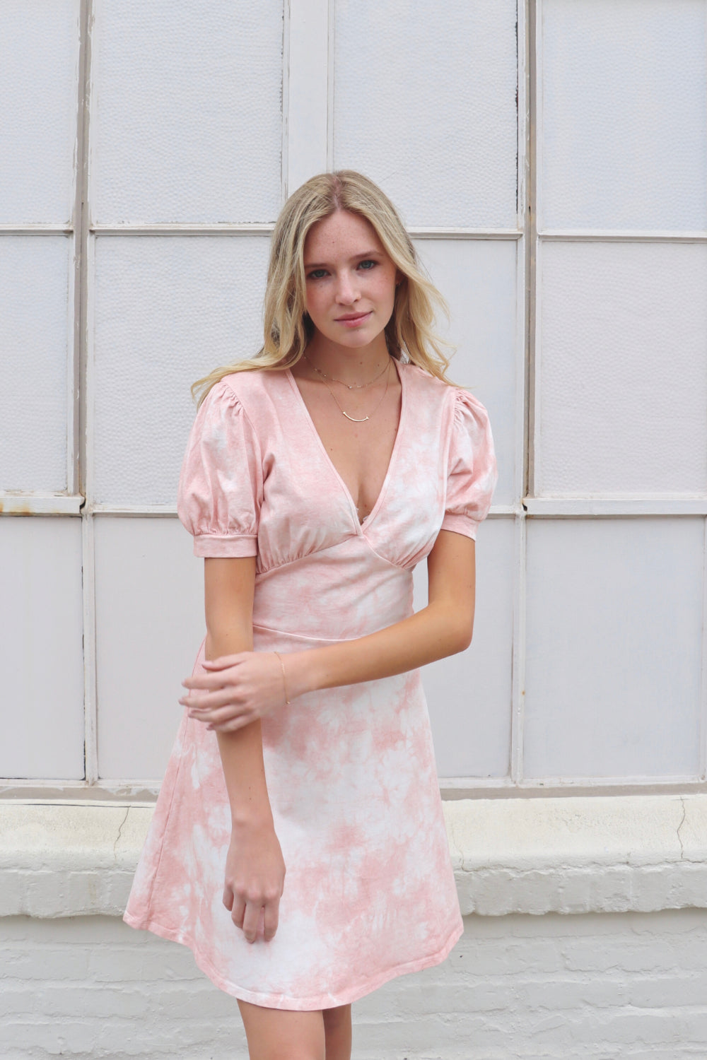 True Romance Dress featuring short puff sleeves and a fitted waist, hand dyed in pastel gray, saddle pink, and yellow tie-dye.