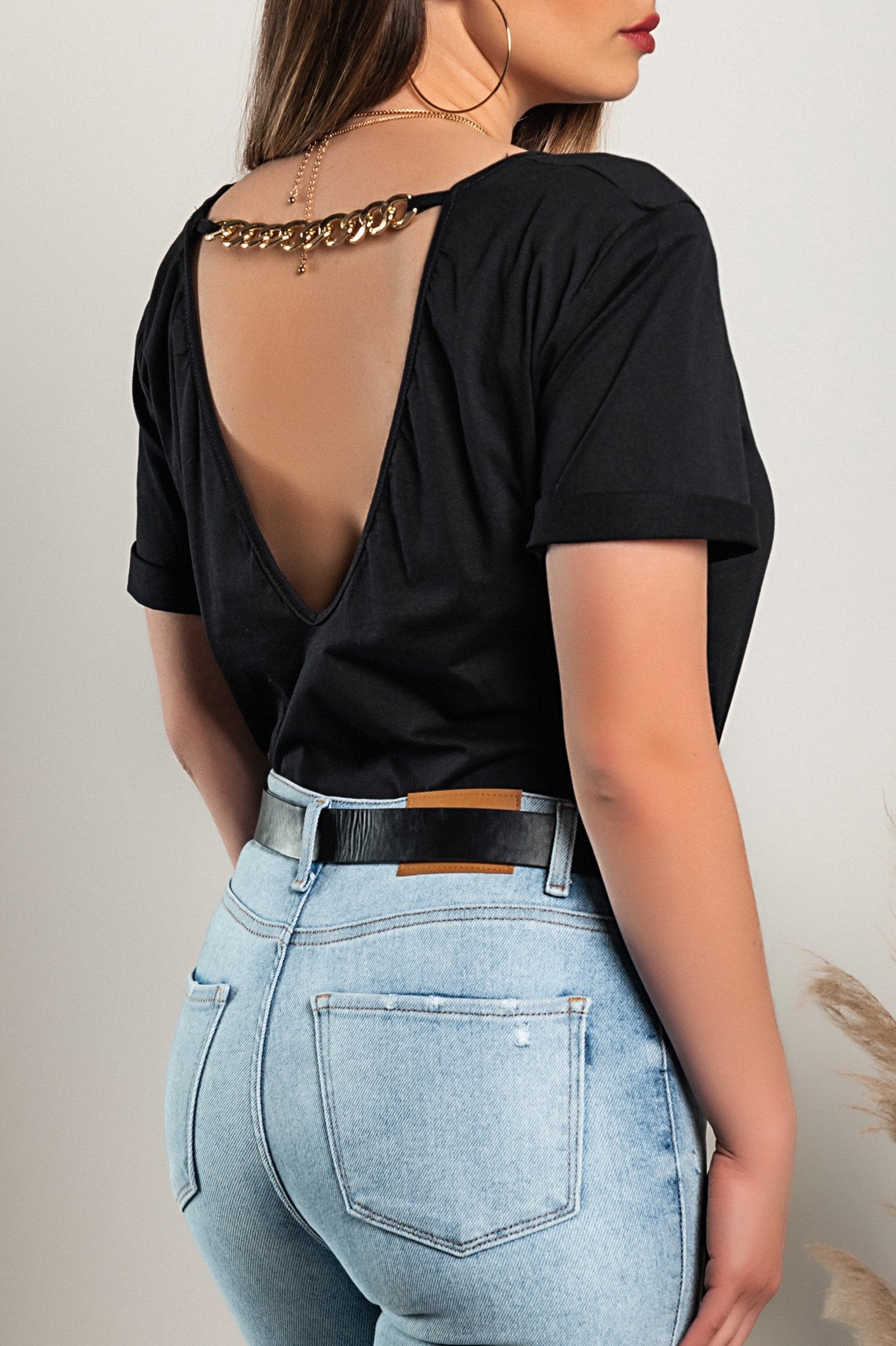 Stylish black T-shirt with decorative detail and deep 'V' neckline, perfect for casual wear.