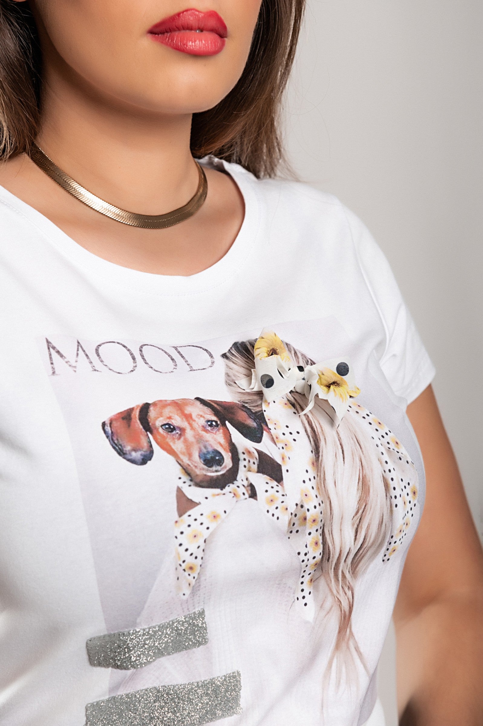 Stylish white T-shirt with short sleeves and decorative details, featuring a round collar and lightweight fabric.