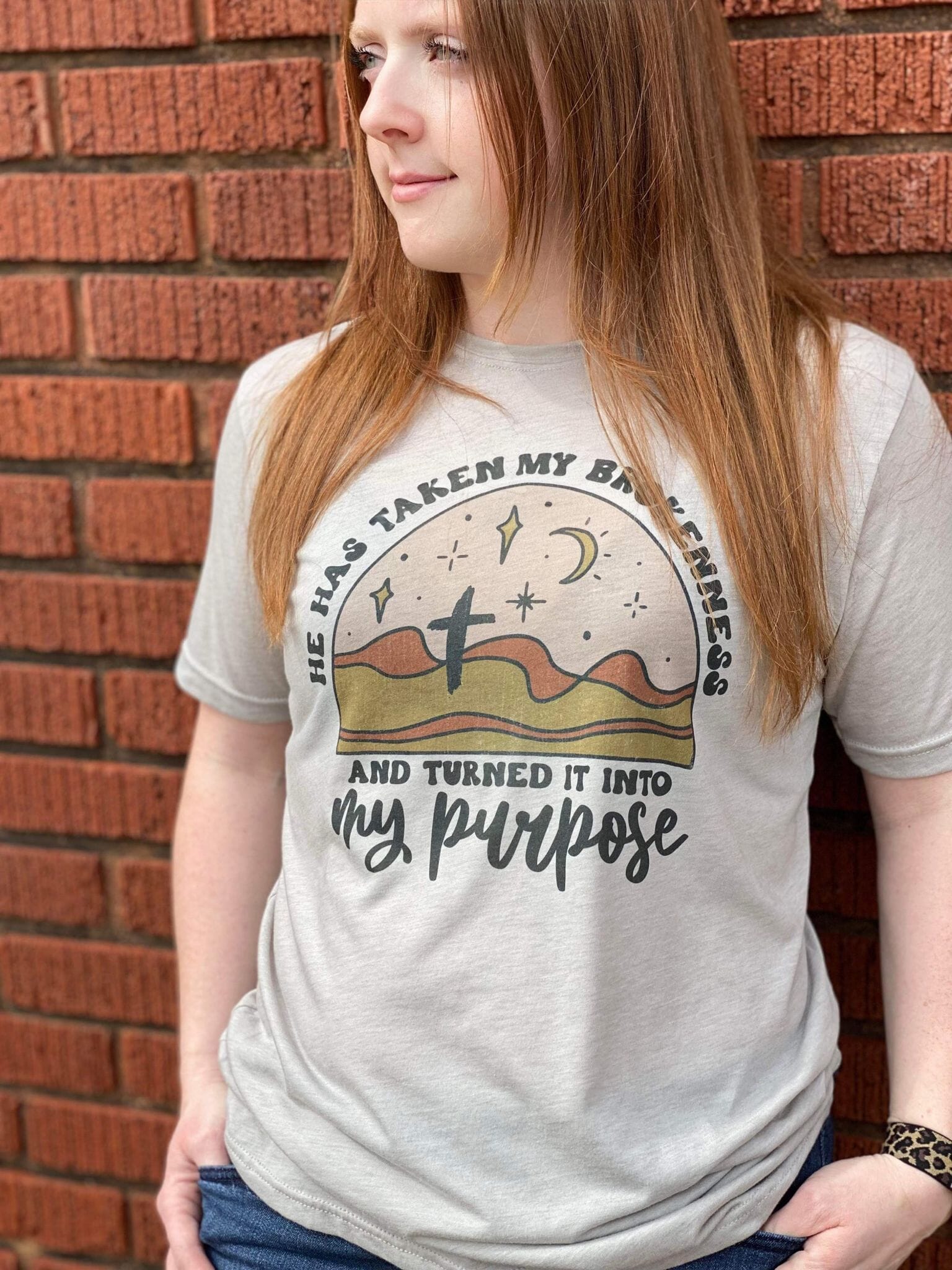 A stylish unisex apparel featuring the phrase 'Turned My Brokenness Into My Purpose' in vibrant colors, made from a soft poly-cotton blend.