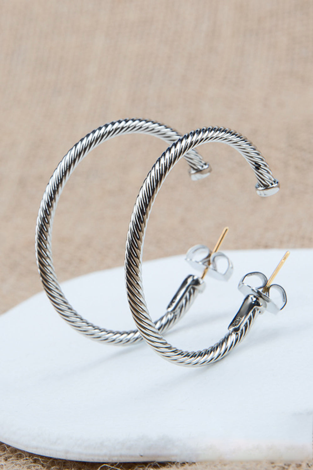 Twisted Copper C-Hoop Earrings displayed in a flat lay style, showcasing their modern minimalist design and 18k platinum-plated finish.