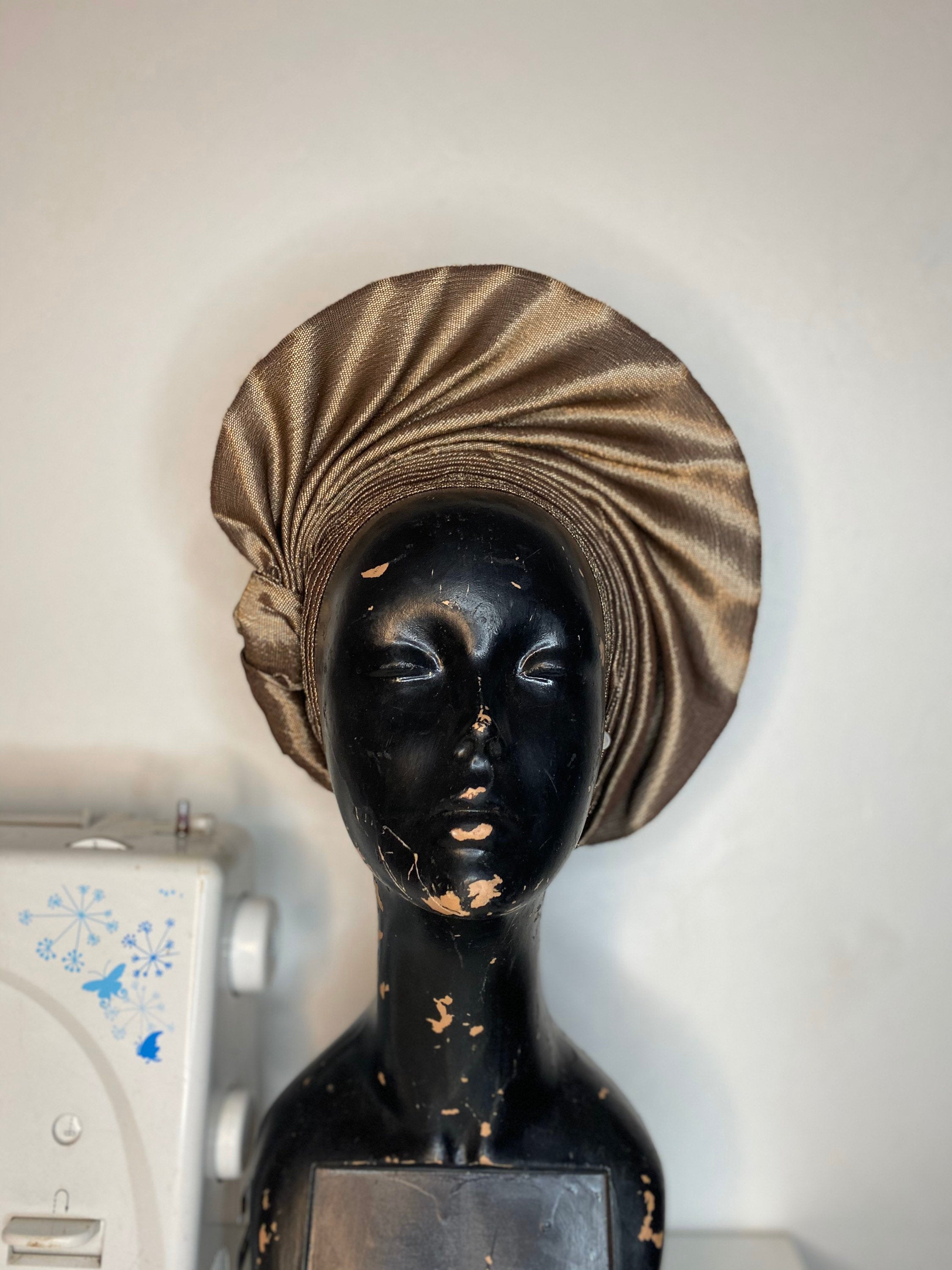 Two-tone African gele headgear displayed in a stylish box, showcasing its vibrant colors and elegant design.