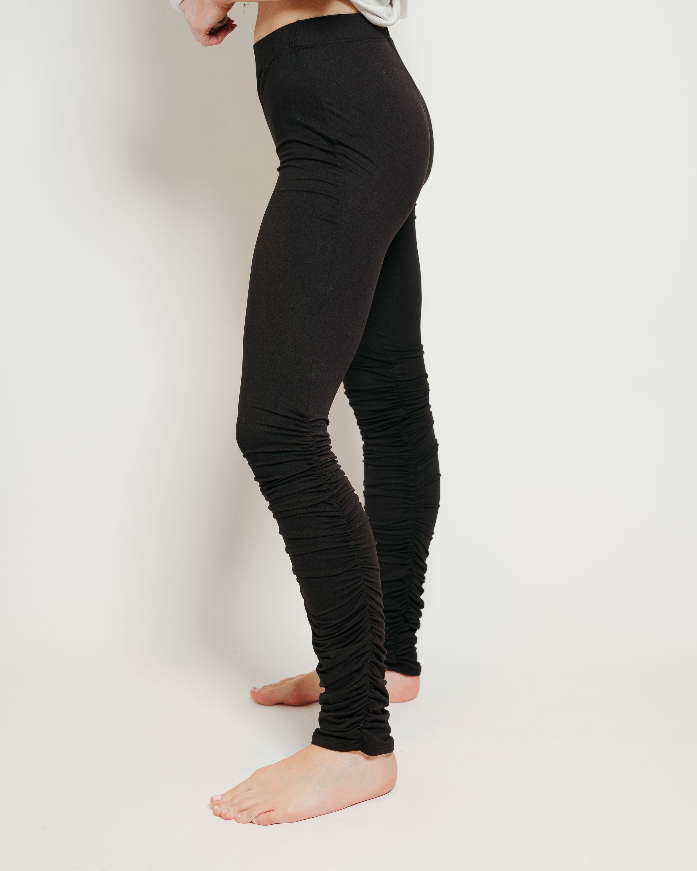 A pair of ultra soft black stacked leggings featuring ruffled bottoms and a stretchy waistband, perfect for comfort and style.