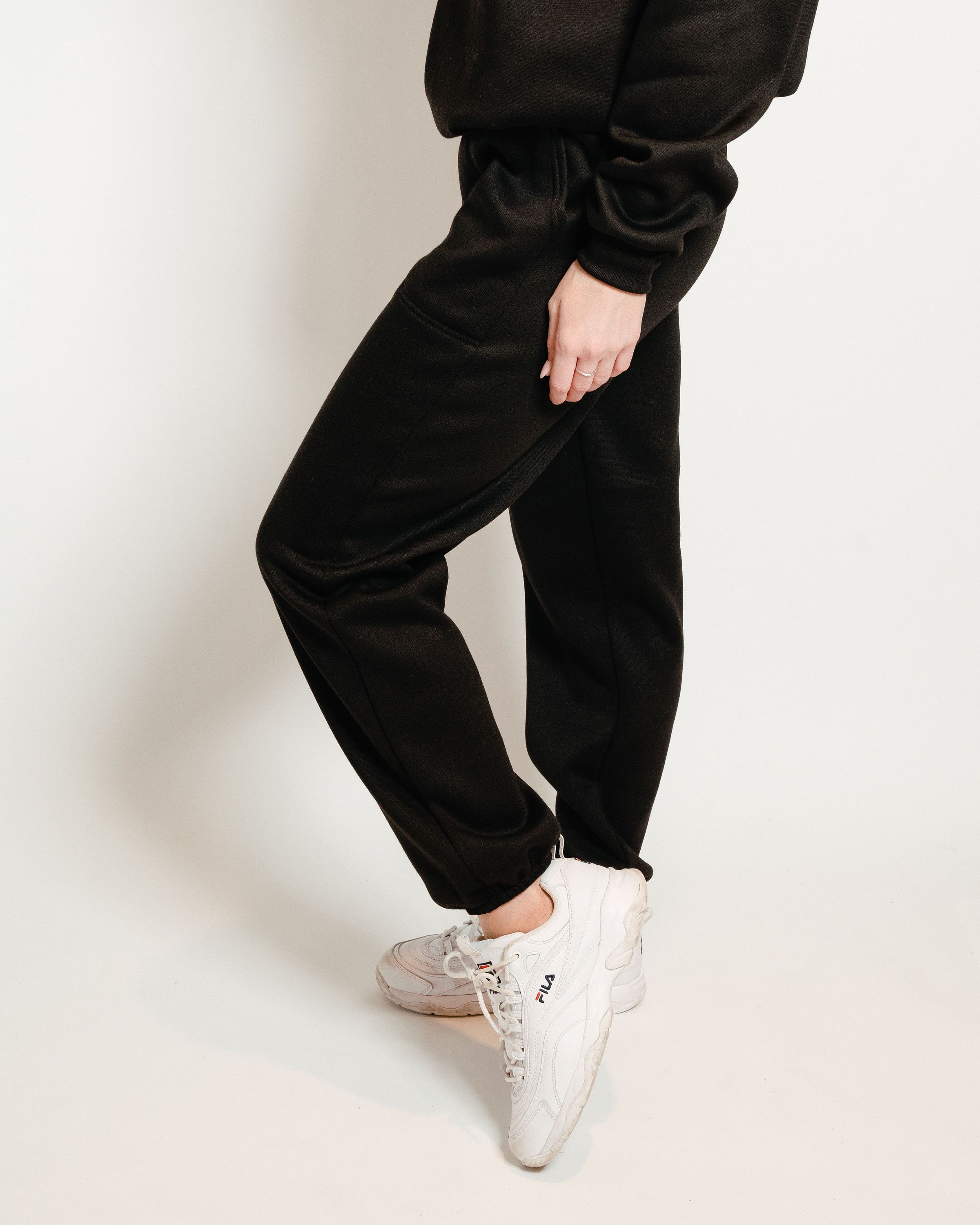 A pair of black unisex sweatpants, showcasing a soft interior and gender-neutral design, perfect for lounging or casual outings.