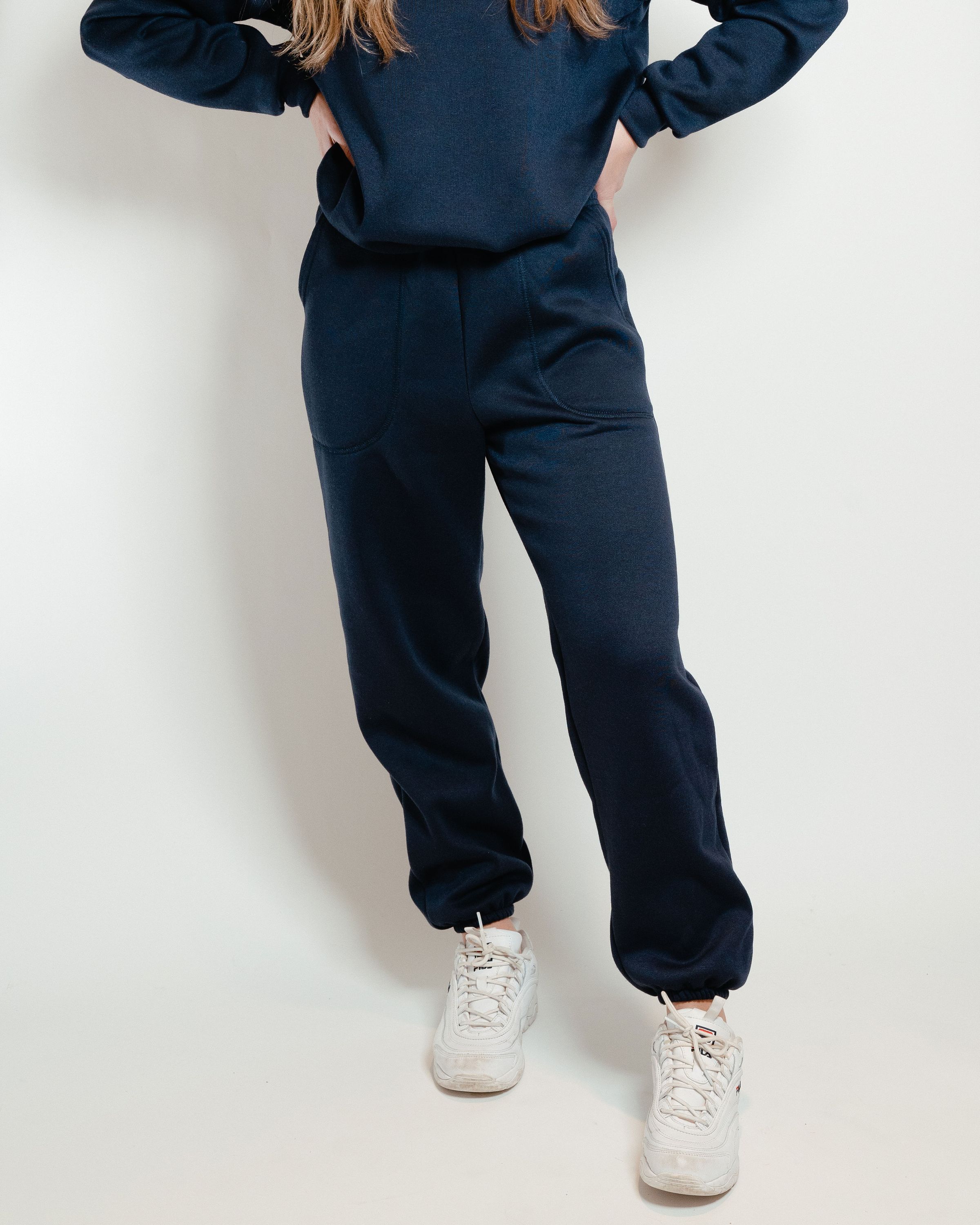 A pair of navy unisex sweatpants featuring a soft interior, perfect for lounging or casual outings.