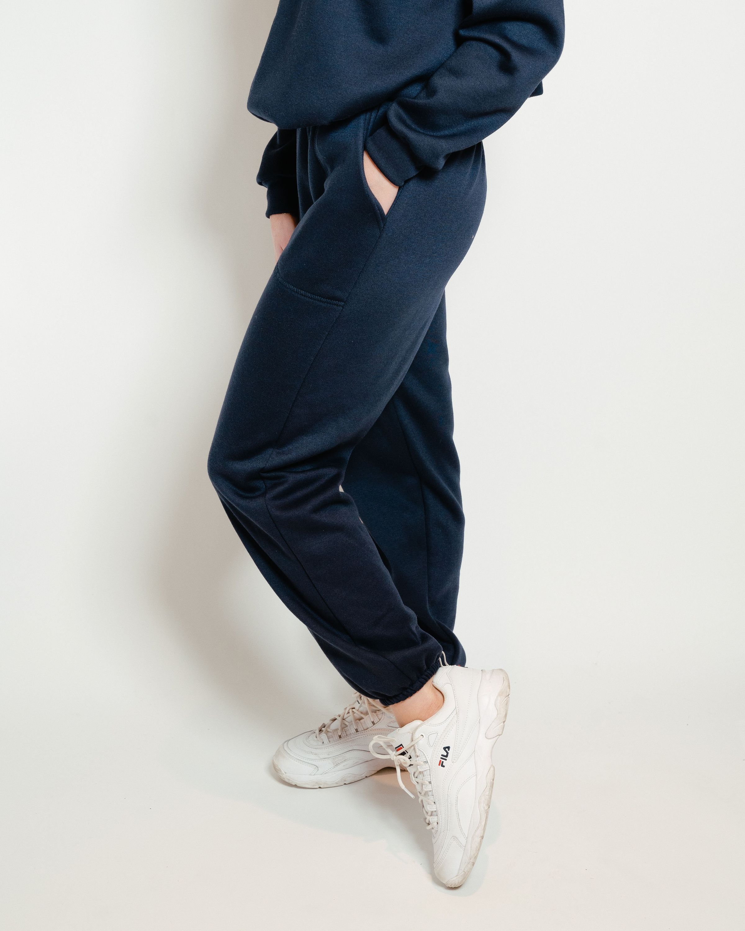 A pair of navy unisex sweatpants featuring a soft interior, perfect for lounging or casual outings.