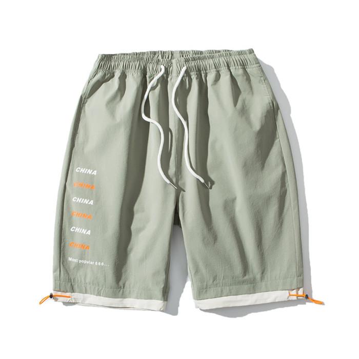 US Stock Men's Tooling Shorts in a casual outdoor setting, showcasing the breathable polyester material and drawstring closure.