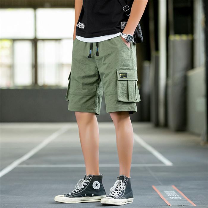 US Stock Men's Tooling Shorts in casual outdoor setting, showcasing drawstring closure and lightweight polyester material.