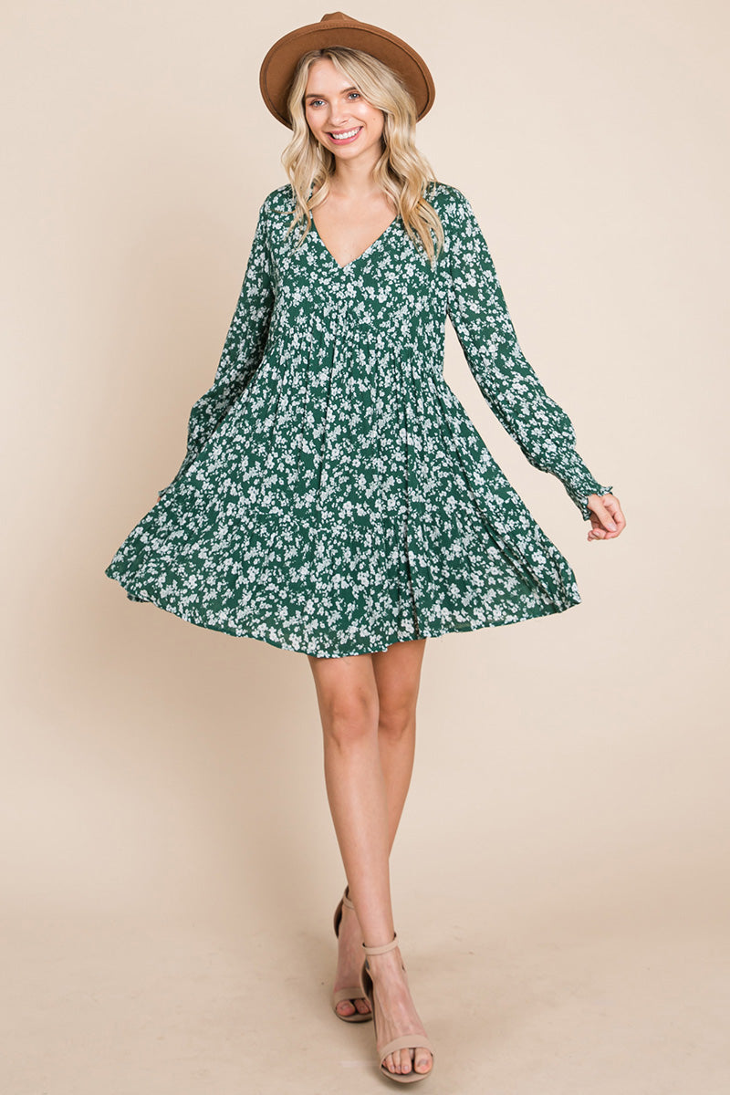 A stylish V neck floral printed long sleeve pleated dress, featuring smocked sleeves and a mini length, perfect for various occasions.