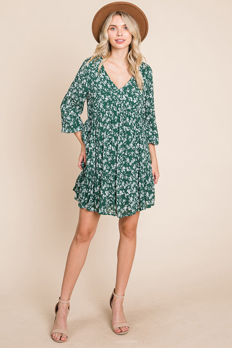 A stylish V neck floral printed long sleeve pleated dress, featuring smocked sleeves and a mini length, perfect for various occasions.