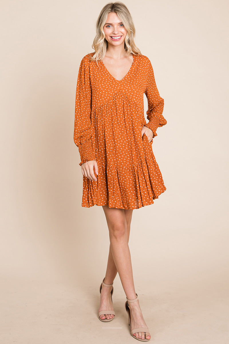 A stylish V neck floral printed long sleeve pleated dress, featuring smocked sleeves and a mini length, perfect for various occasions.