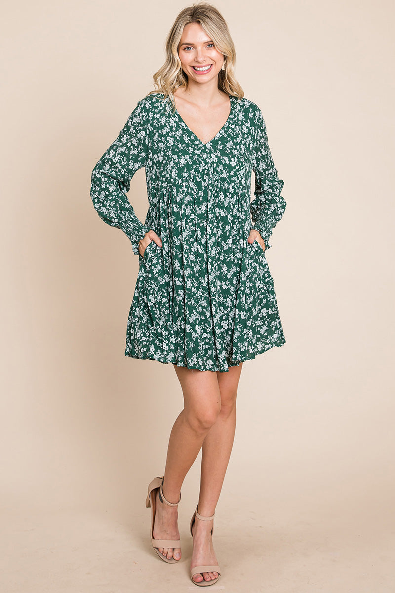 A stylish V neck floral printed long sleeve pleated dress, featuring smocked sleeves and a mini length, perfect for various occasions.