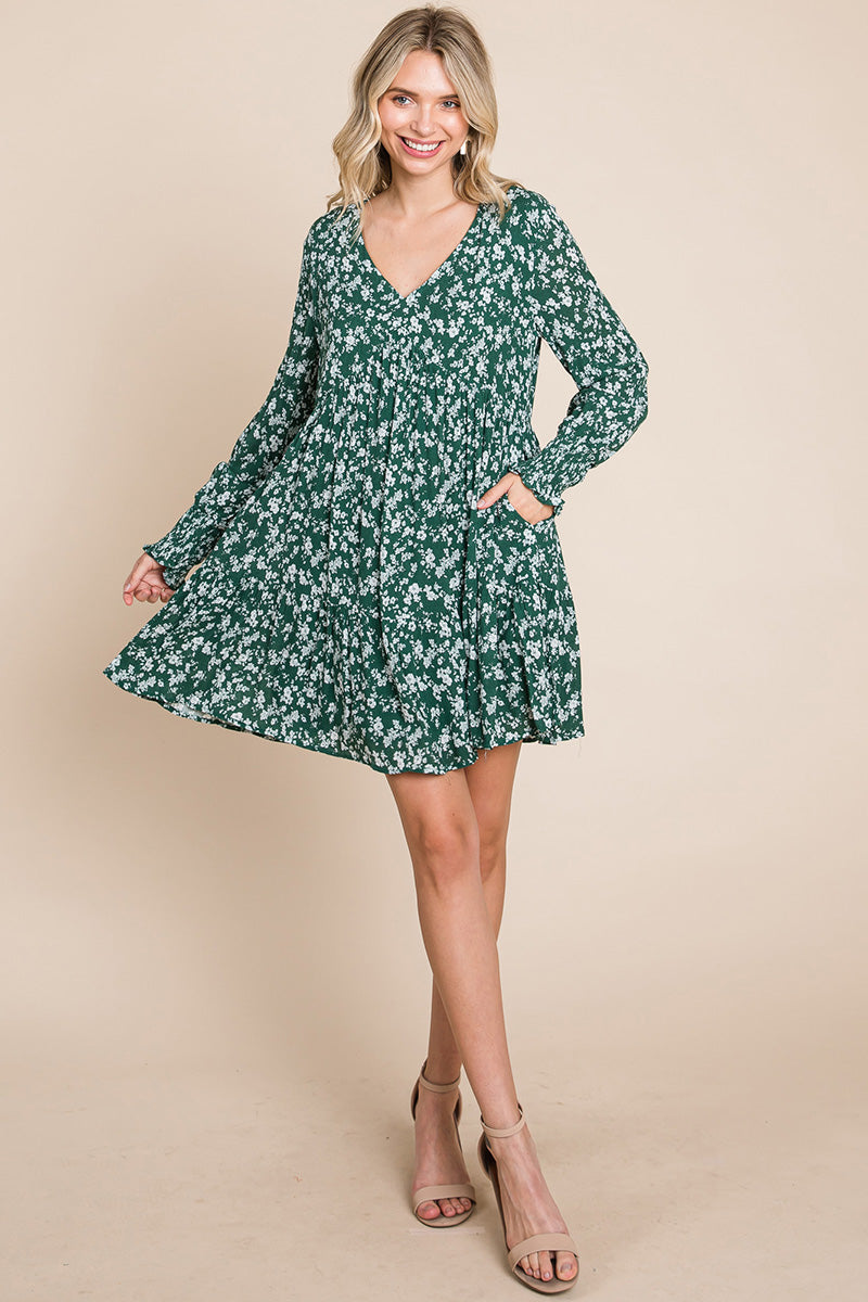 A stylish V neck floral printed long sleeve pleated dress, featuring smocked sleeves and a mini length, perfect for various occasions.